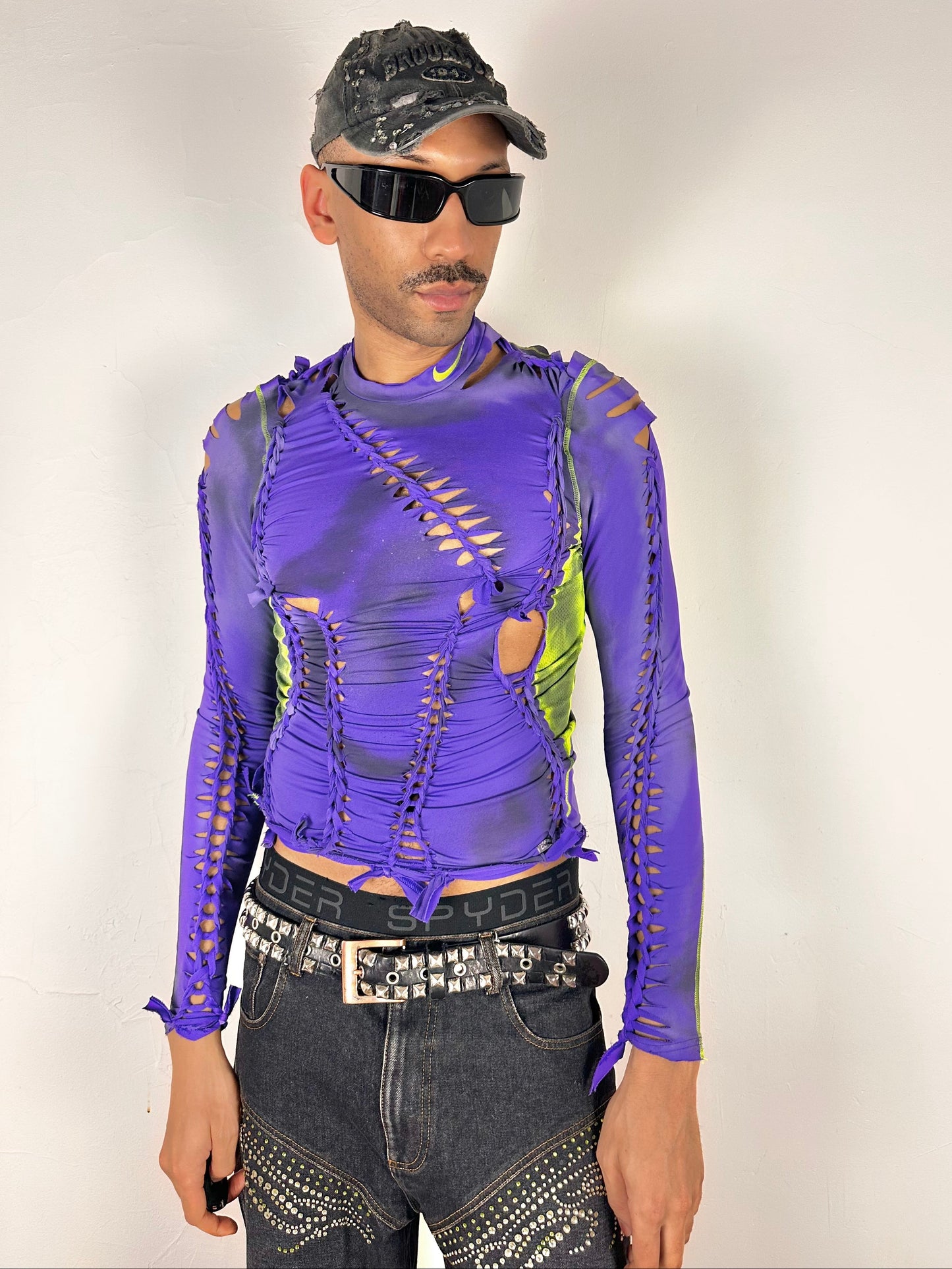 Styled image of ASTROBOI* x Nike Pro purple and green braided compression top in medium with airbrushed details, mesh side panels, and slim athletic fit.