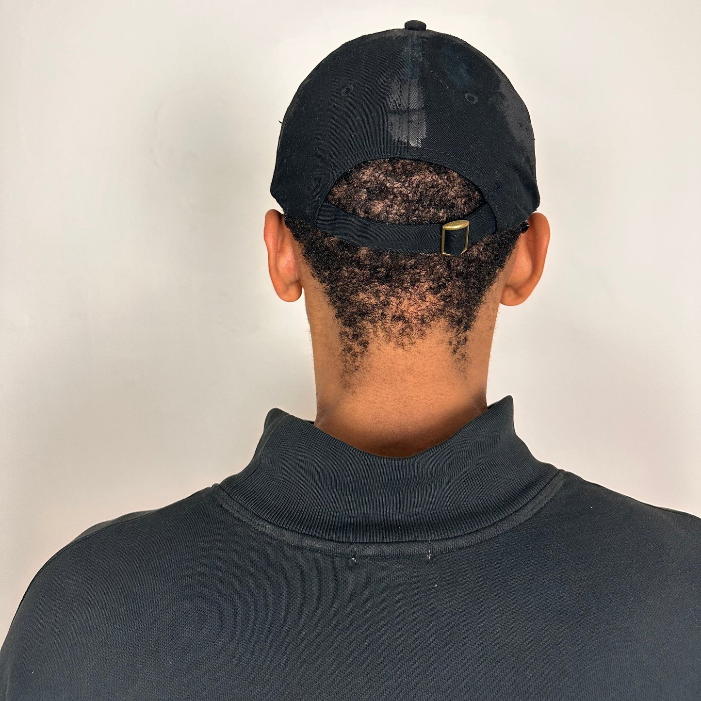 Back side of Black distressed ASTROBOI* ‘Daddy’ hat with custom paint detailing and stainless steel piercings, handcrafted in NYC.