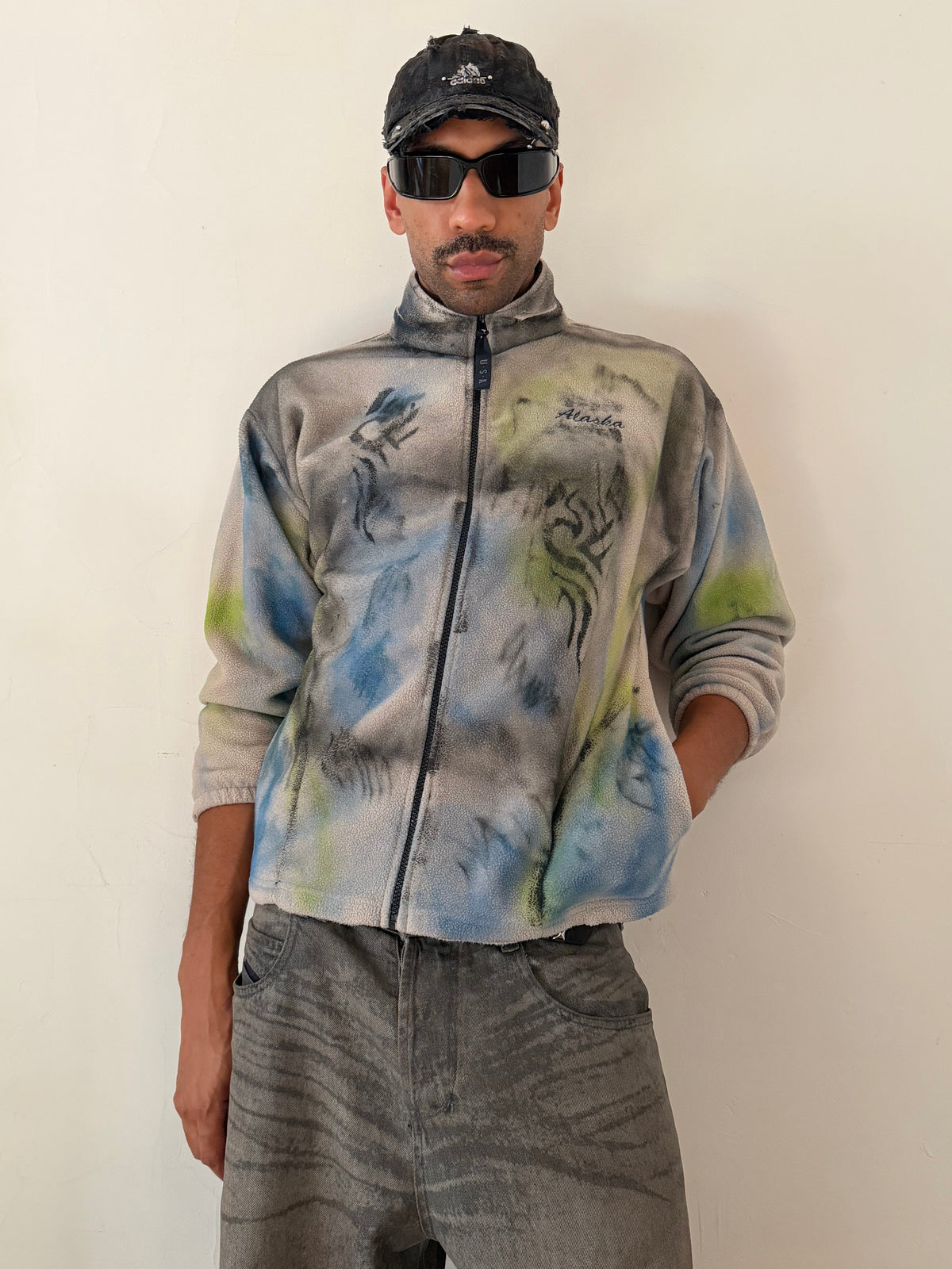 Male model wearing ASTROBOI* ‘Alaska’ Y2K tan tattoo print fleece zip up sweatshirt, styled full look, ASTROBOI* STUDIO NYC.