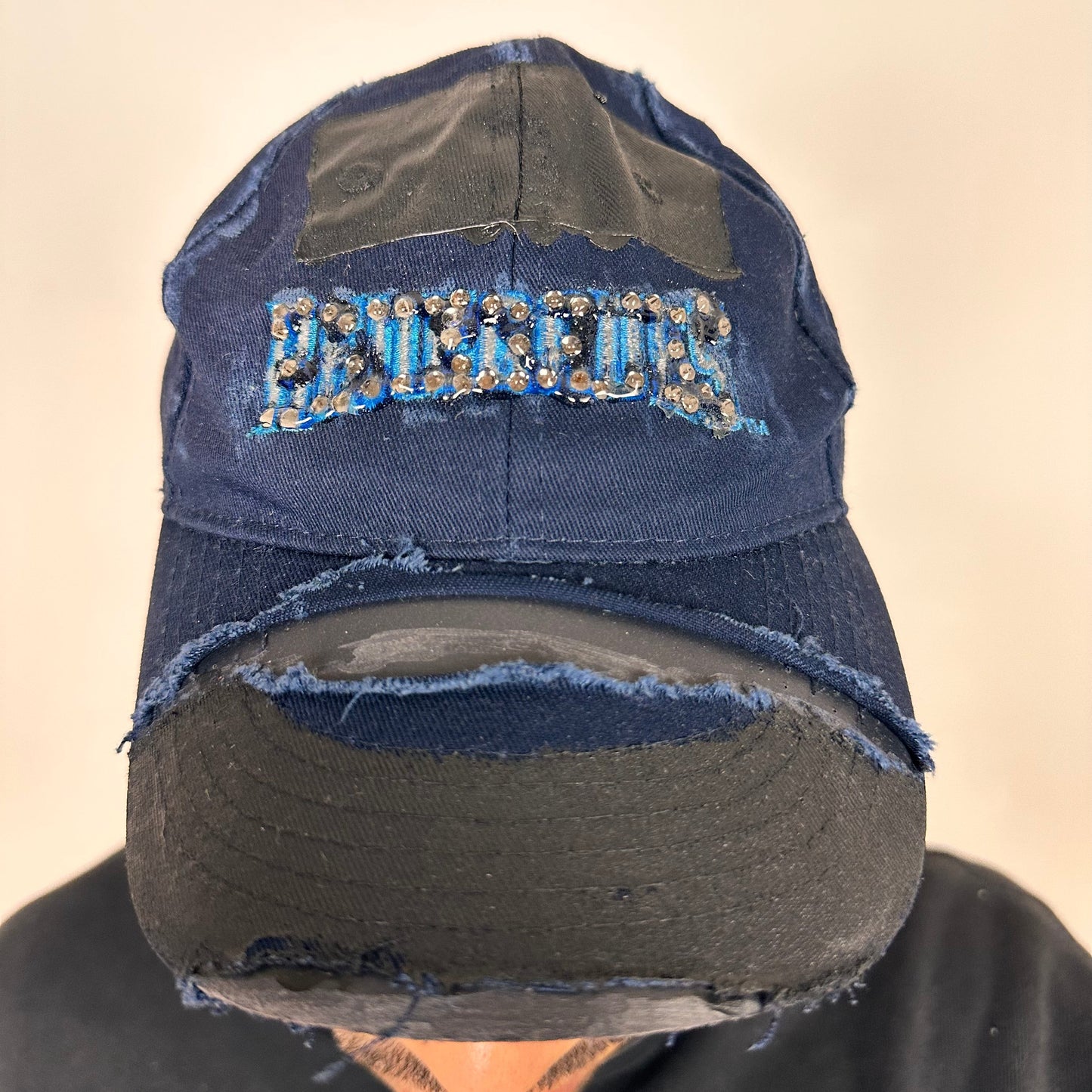 Cover image of ASTROBOI* x Renegades navy distressed hat with resin-sealed rhinestones and tattoo-style paint details. One-of-one custom piece made in NYC.