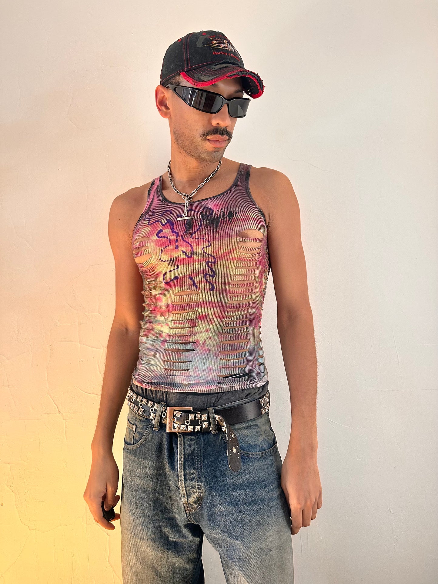 Styled image of ASTROBOI* x Hanes 'Skies' tank top showing abstract purple wavy chest graphic and hand-painted tie dye detail, front view.