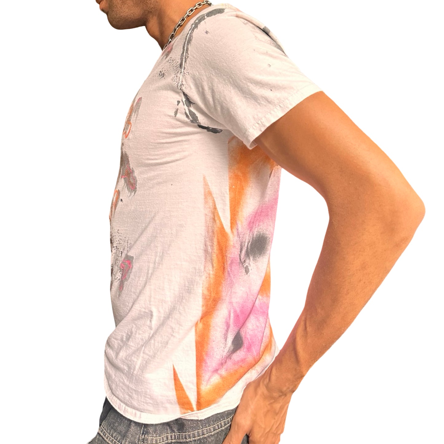 Person wearing a white t-shirt with colorful abstract design on a plain background