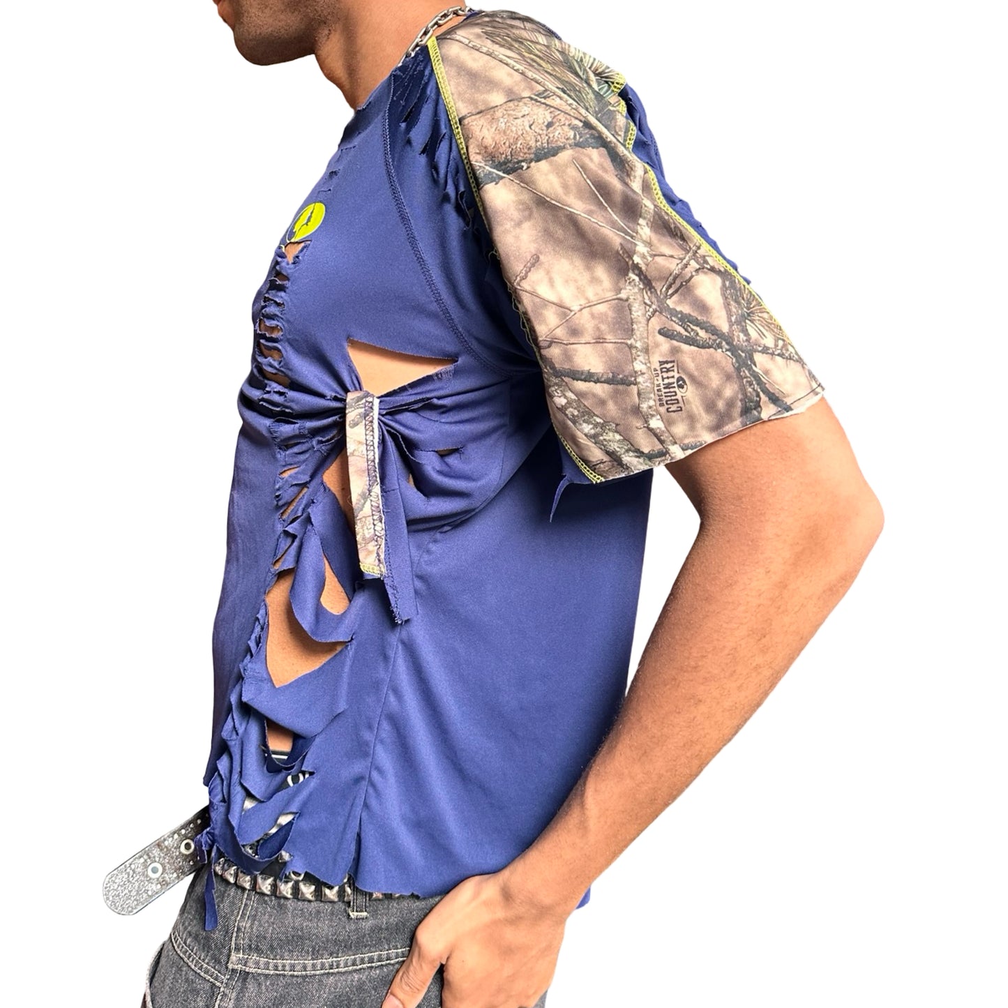 Person wearing a blue top with cut-out design and camouflage sleeve on a white background