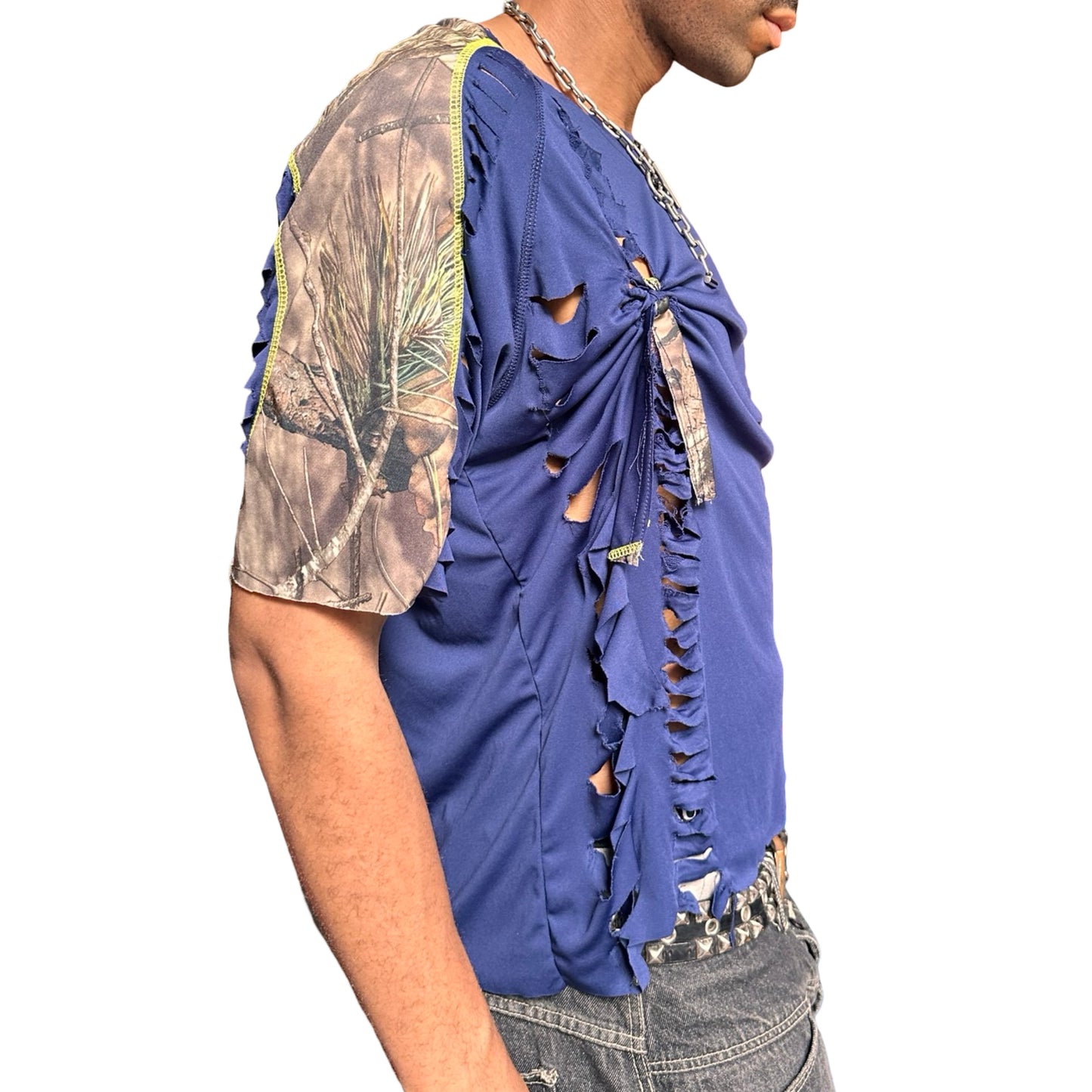 Person wearing a blue distressed t-shirt with camouflage sleeves on a white background