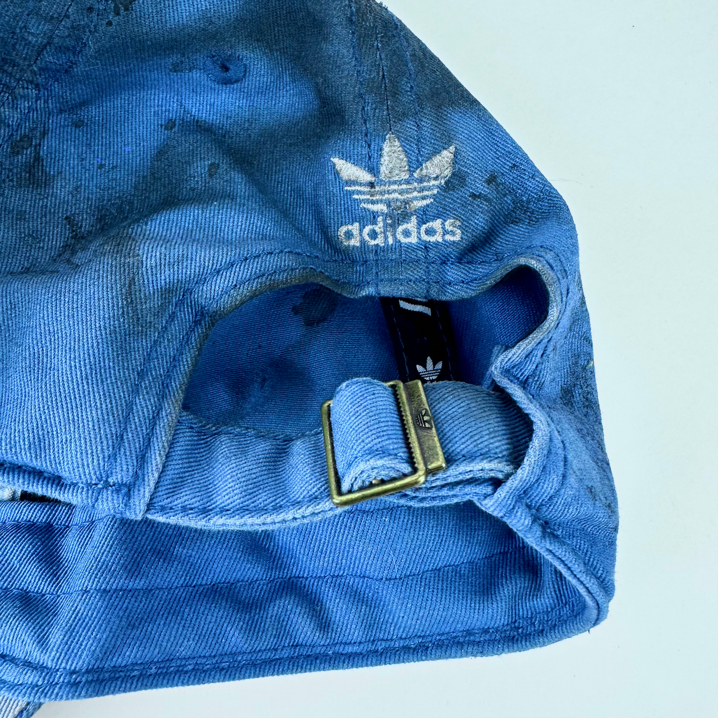 ASTROBOI* x Adidas 'H Chic' tan distressed grunge hat, rear view showing black duct tape accent detail and adjustable strap with back logo embroidery. 
