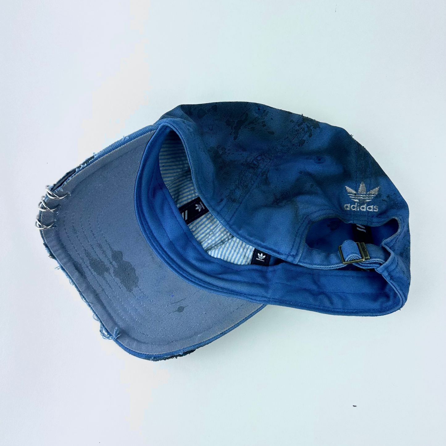 ASTROBOI* x Adidas 'H Chic' tan distressed grunge hat, rear view showing black duct tape accent detail and adjustable strap.