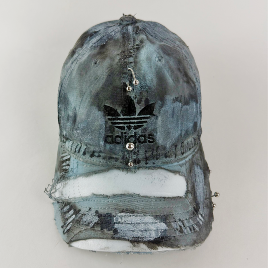ASTROBOI* x Adidas 'Margiela' blue and black distressed pierced cap with embroidered Adidas logo and custom painterly treatment.