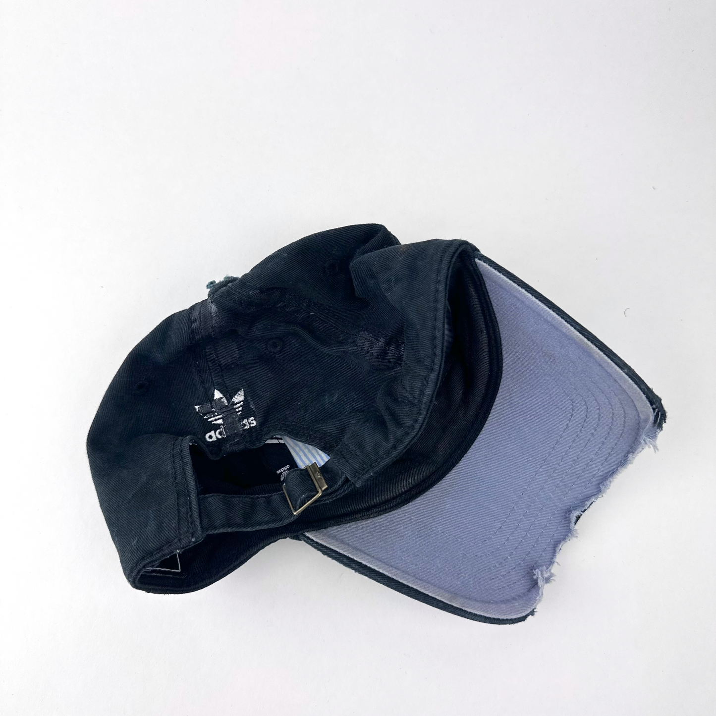 ASTROBOI* x Adidas 'Washed' black distressed faded cap, rear view showing Adidas trefoil back logo and adjustable strap.