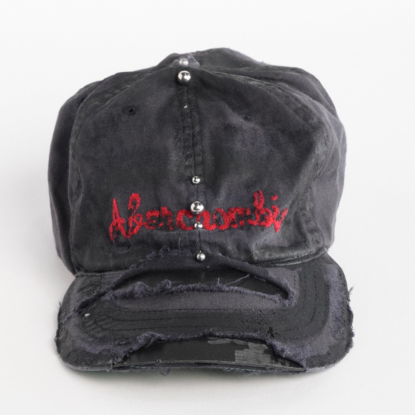 Front of Navy ASTROBOI* x Abercrombie hat with distressed paint, stainless steel piercings, and logo embroidery on front and back, customized in NYC.