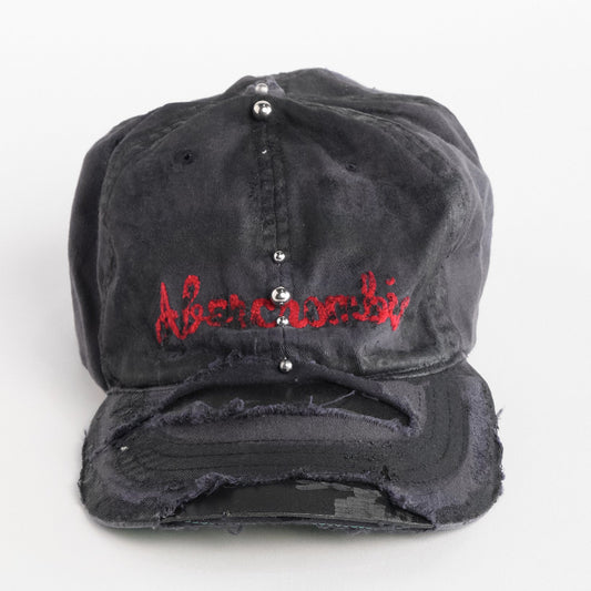 Front of Navy ASTROBOI* x Abercrombie hat with distressed paint, stainless steel piercings, and logo embroidery on front and back, customized in NYC.