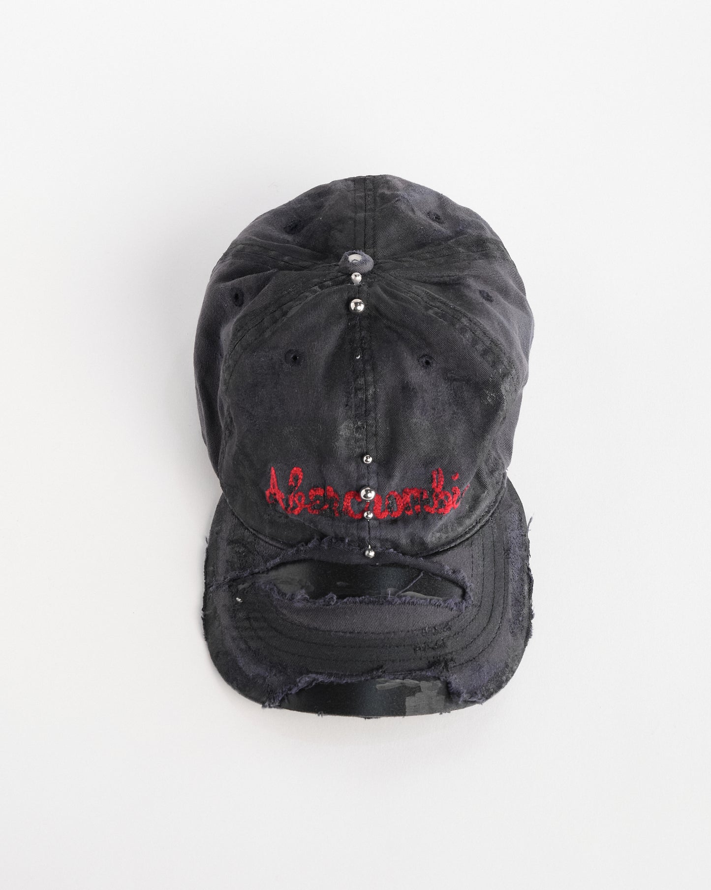 Front overview of Navy ASTROBOI* x Abercrombie hat with distressed paint, stainless steel piercings, and logo embroidery on front and back, customized in NYC.