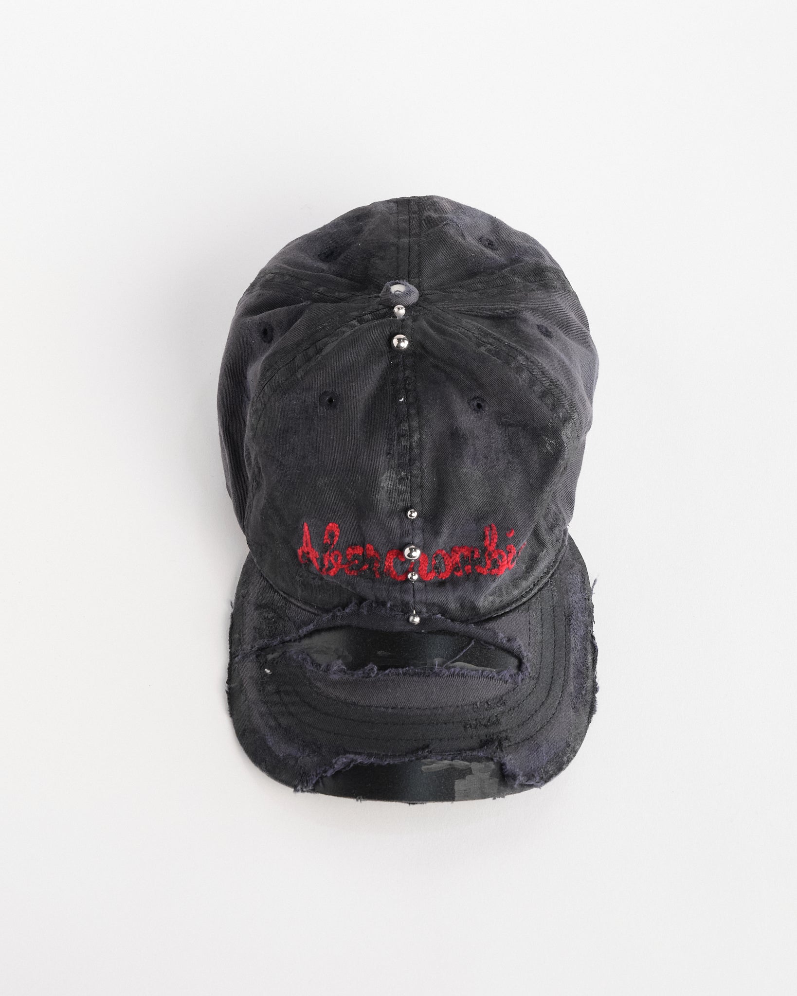 Front overview of Navy ASTROBOI* x Abercrombie hat with distressed paint, stainless steel piercings, and logo embroidery on front and back, customized in NYC.
