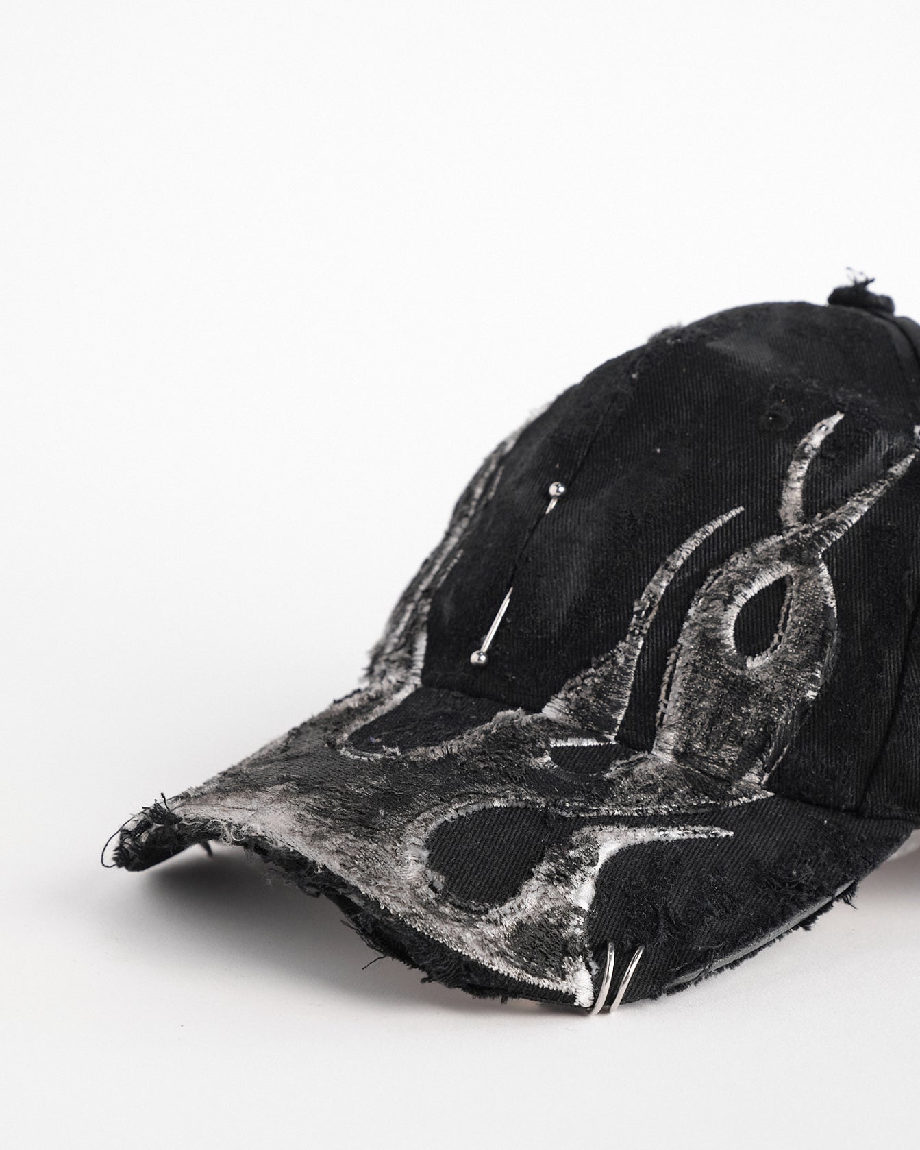 Left front detail of ASTROBOI* 'Black Flame' Y2K Black & Silver Distressed Pierced Hat 