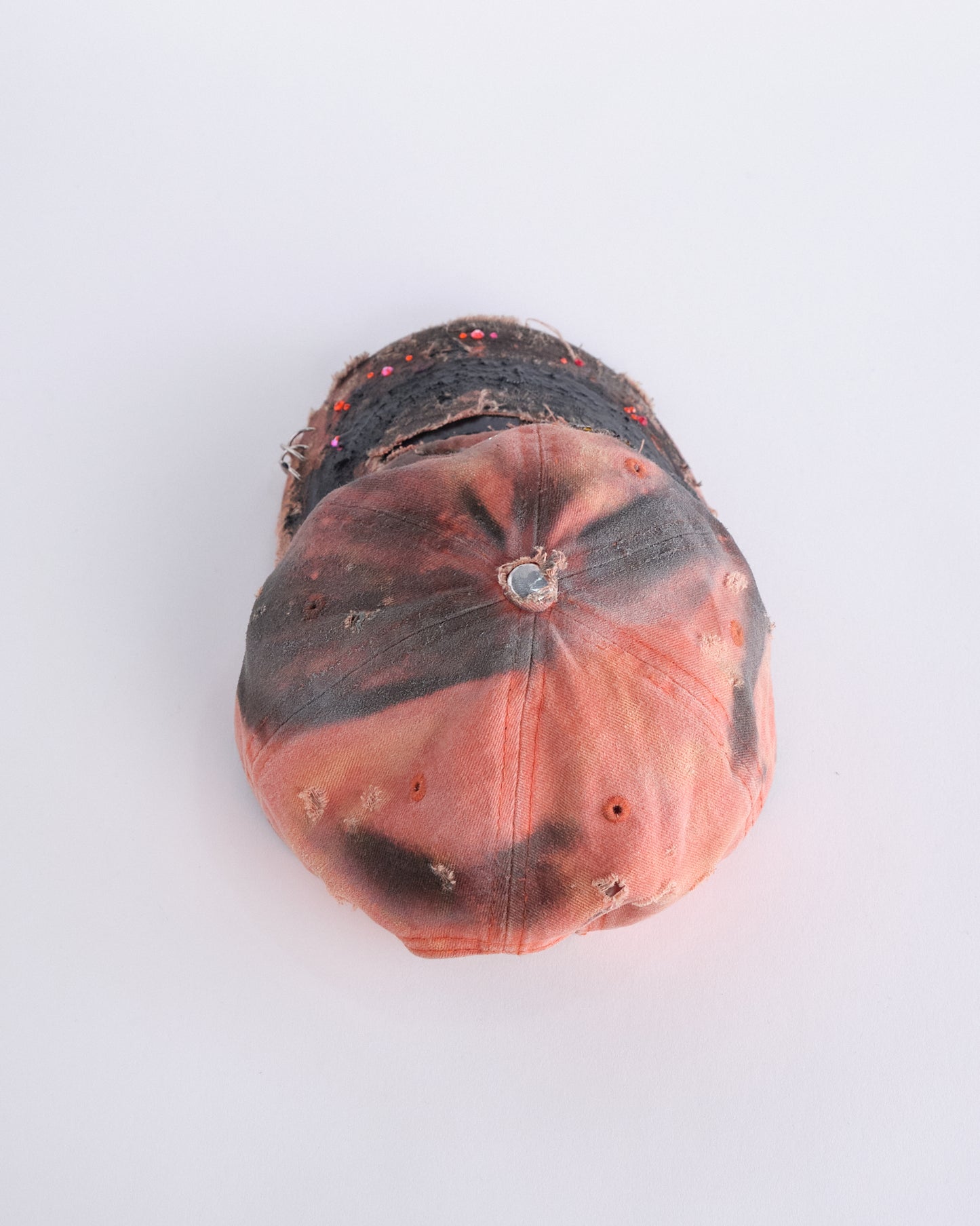 Top of ASTROBOI* Costa Rica orange distressed hat with rhinestones, black resin accents, stainless steel piercings, and adjustable strap, handmade in NYC.