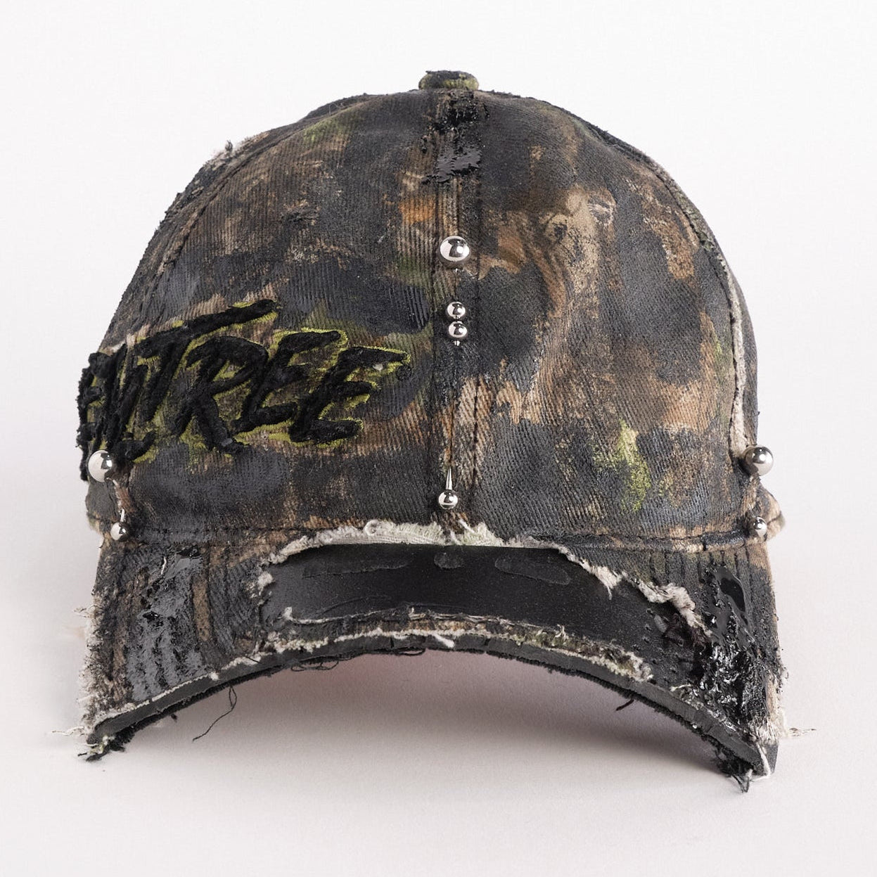 Front of Brown RealTree distressed half-visor hat with elastic base, black resin detailing, and a sawed-off visor for a deconstructed Y2K aesthetic.