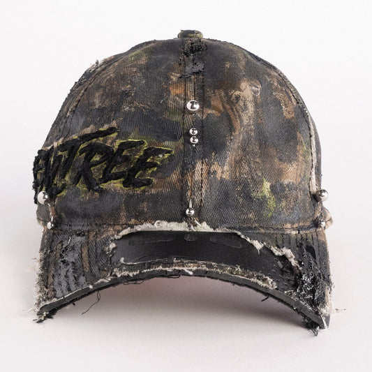 Front of Brown RealTree distressed half-visor hat with elastic base, black resin detailing, and a sawed-off visor for a deconstructed Y2K aesthetic.