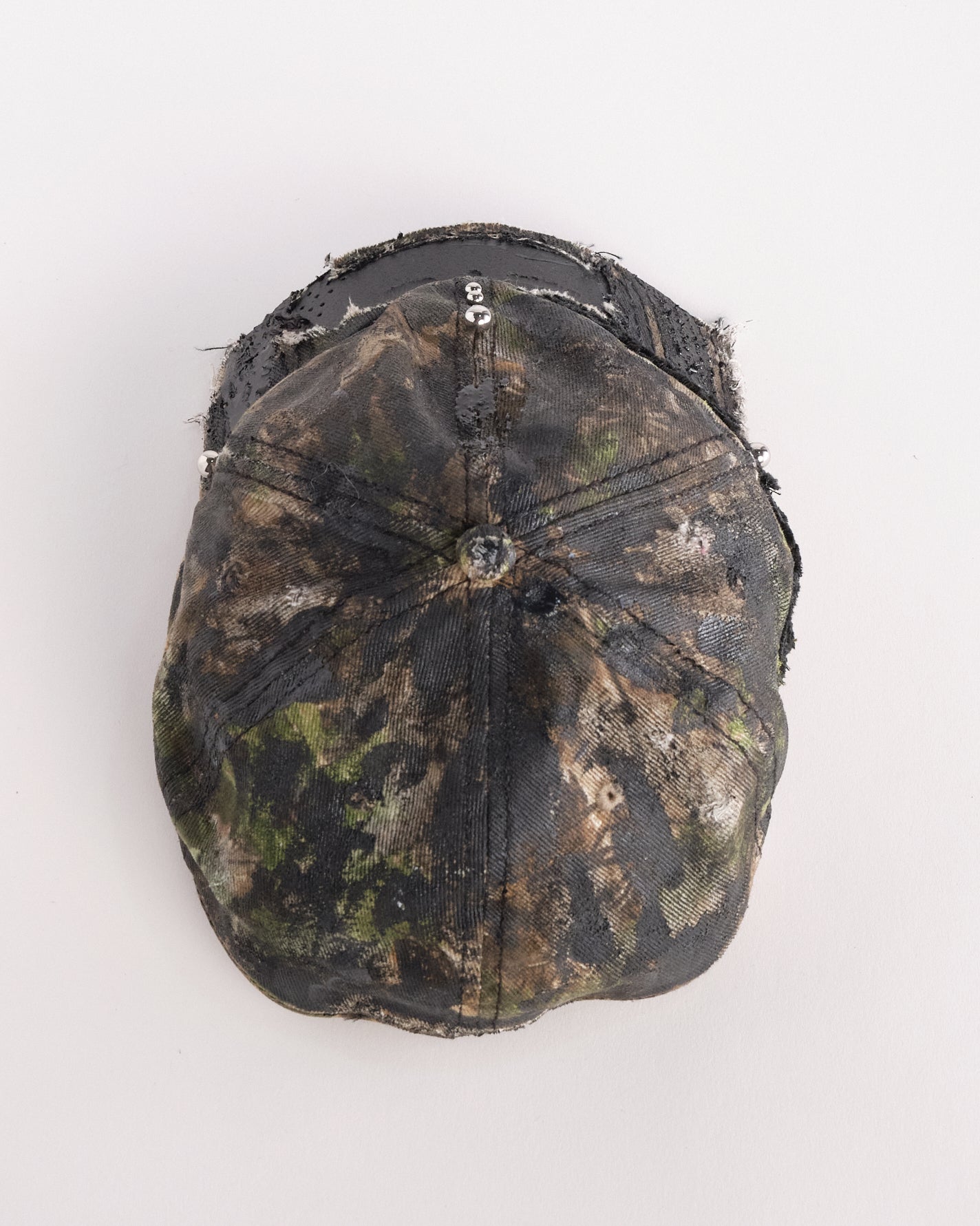 Top of Brown RealTree distressed half-visor hat with elastic base, black resin detailing, and a sawed-off visor for a deconstructed Y2K aesthetic.