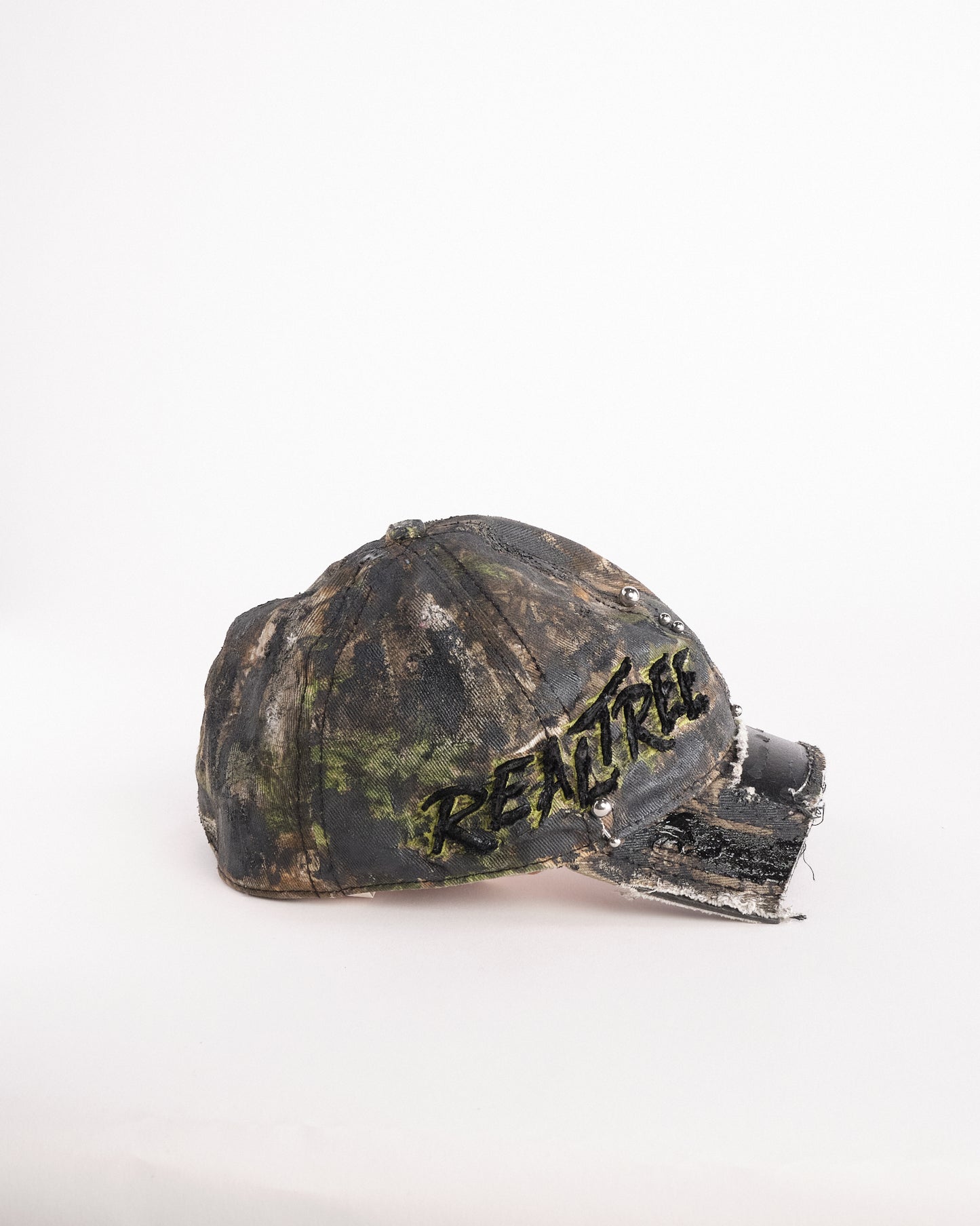 Right side of Brown RealTree distressed half-visor hat with elastic base, black resin detailing, and a sawed-off visor for a deconstructed Y2K aesthetic.