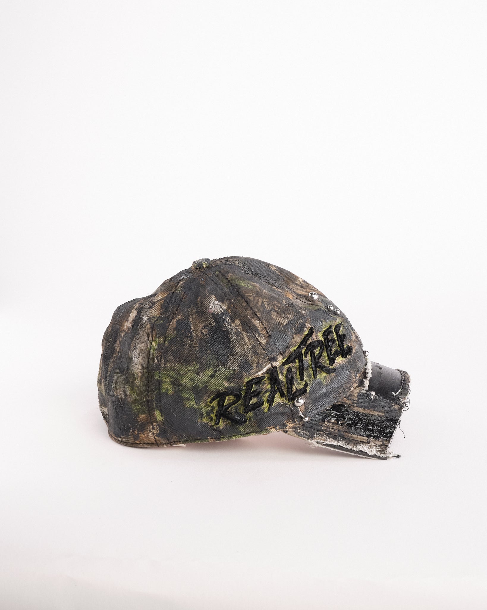 Right side of Brown RealTree distressed half-visor hat with elastic base, black resin detailing, and a sawed-off visor for a deconstructed Y2K aesthetic.