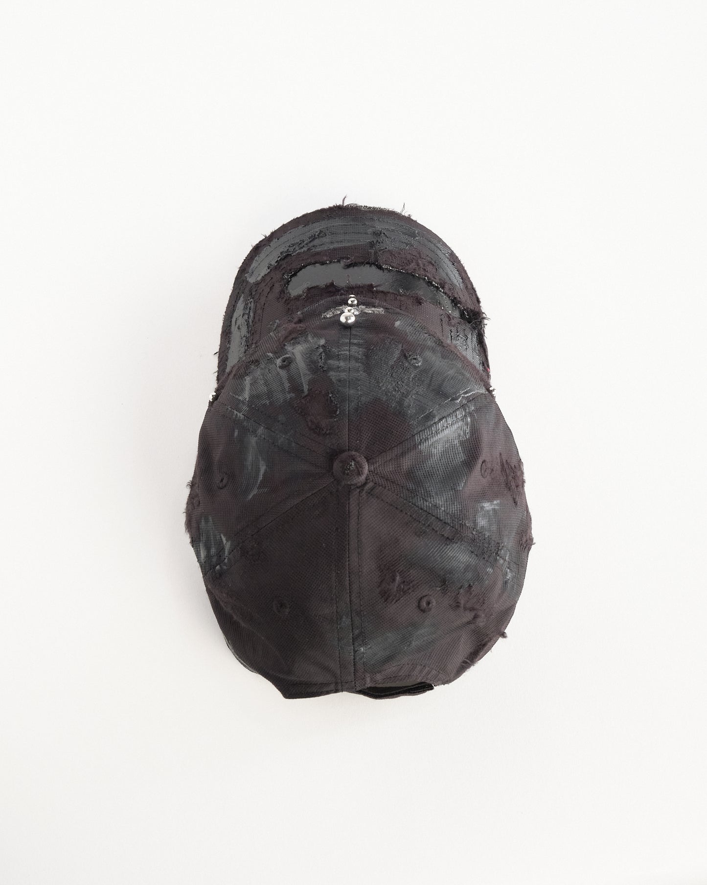 Top of Black Adidas hat customized by ASTROBOI* with distressing, black painted accents, and stainless steel piercings.