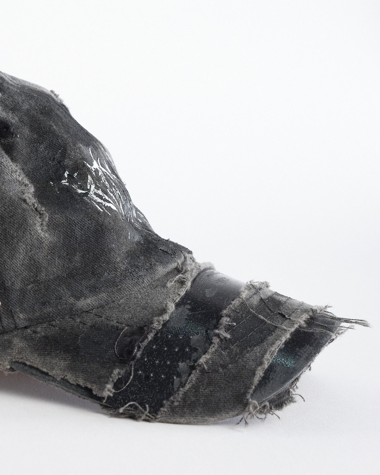 Visor detail on ASTROBOI* indie grunge black distressed hat with barbed wire logo, adjustable strap, and hand-painted raw streetwear detailing, handmade in NYC.