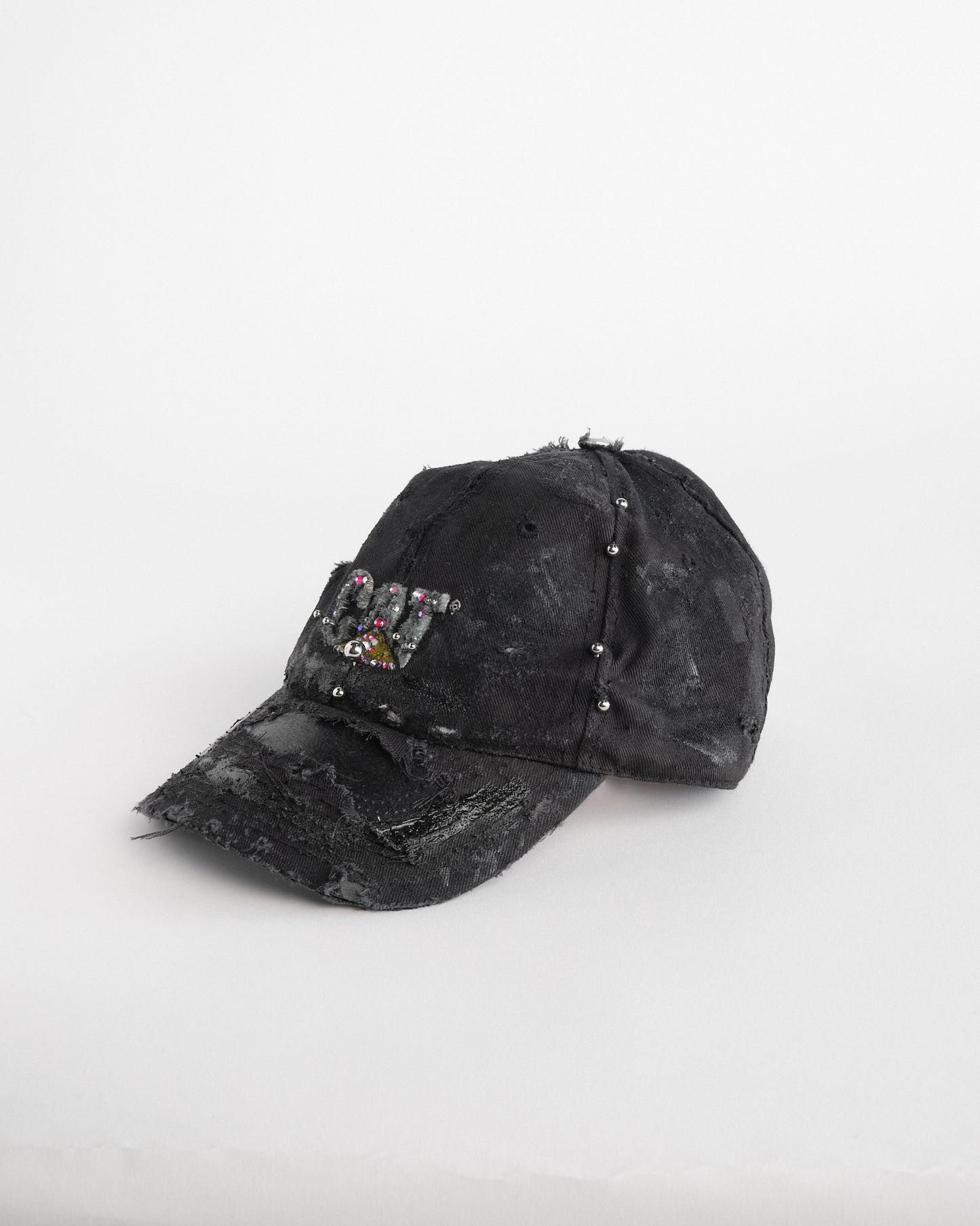 Left of ASTROBOI* x CAT black distressed pierced hat with rhinestone logo, resin and paint detailing, deconstructed visor, adjustable strap, handmade in NYC.