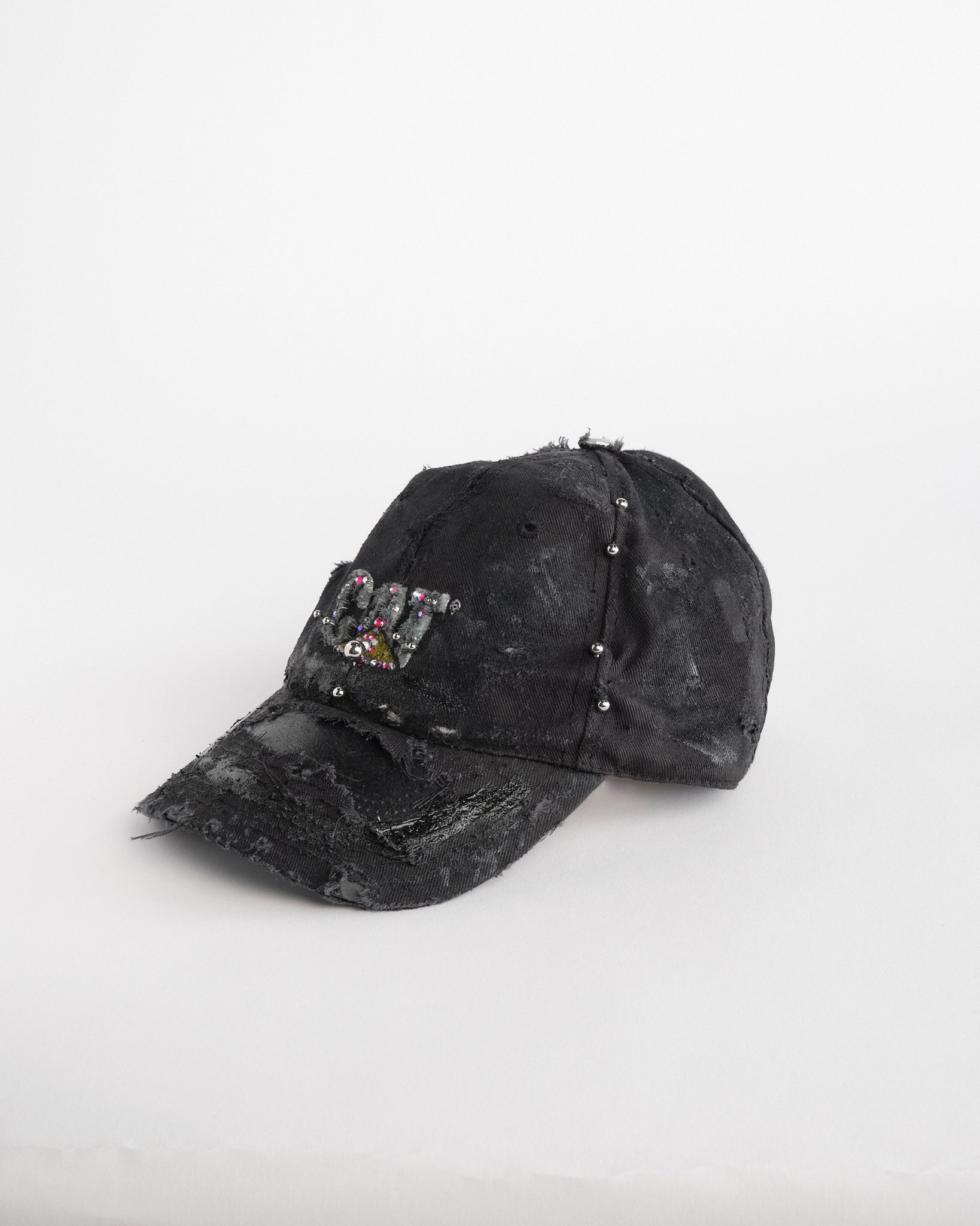 Left of ASTROBOI* x CAT black distressed pierced hat with rhinestone logo, resin and paint detailing, deconstructed visor, adjustable strap, handmade in NYC.