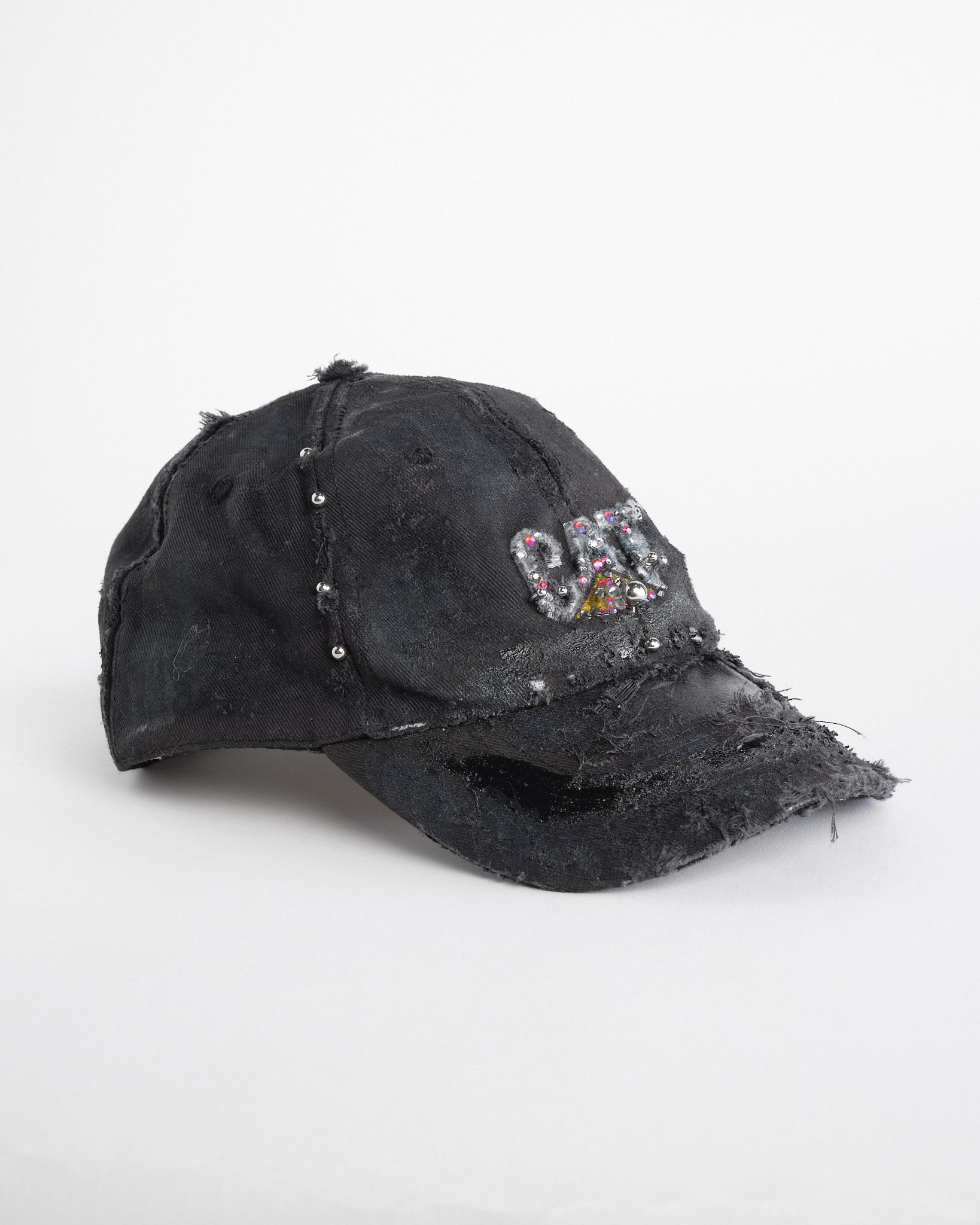 Right side of ASTROBOI* x CAT black distressed pierced hat with rhinestone logo, resin and paint detailing, deconstructed visor, adjustable strap, handmade in NYC.