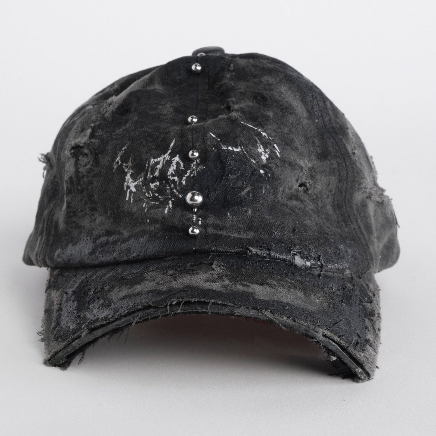 Front of Black distressed half-visor hat with barbed-wire logo, adjustable strap, black paint details, and stainless steel piercings along the brim.