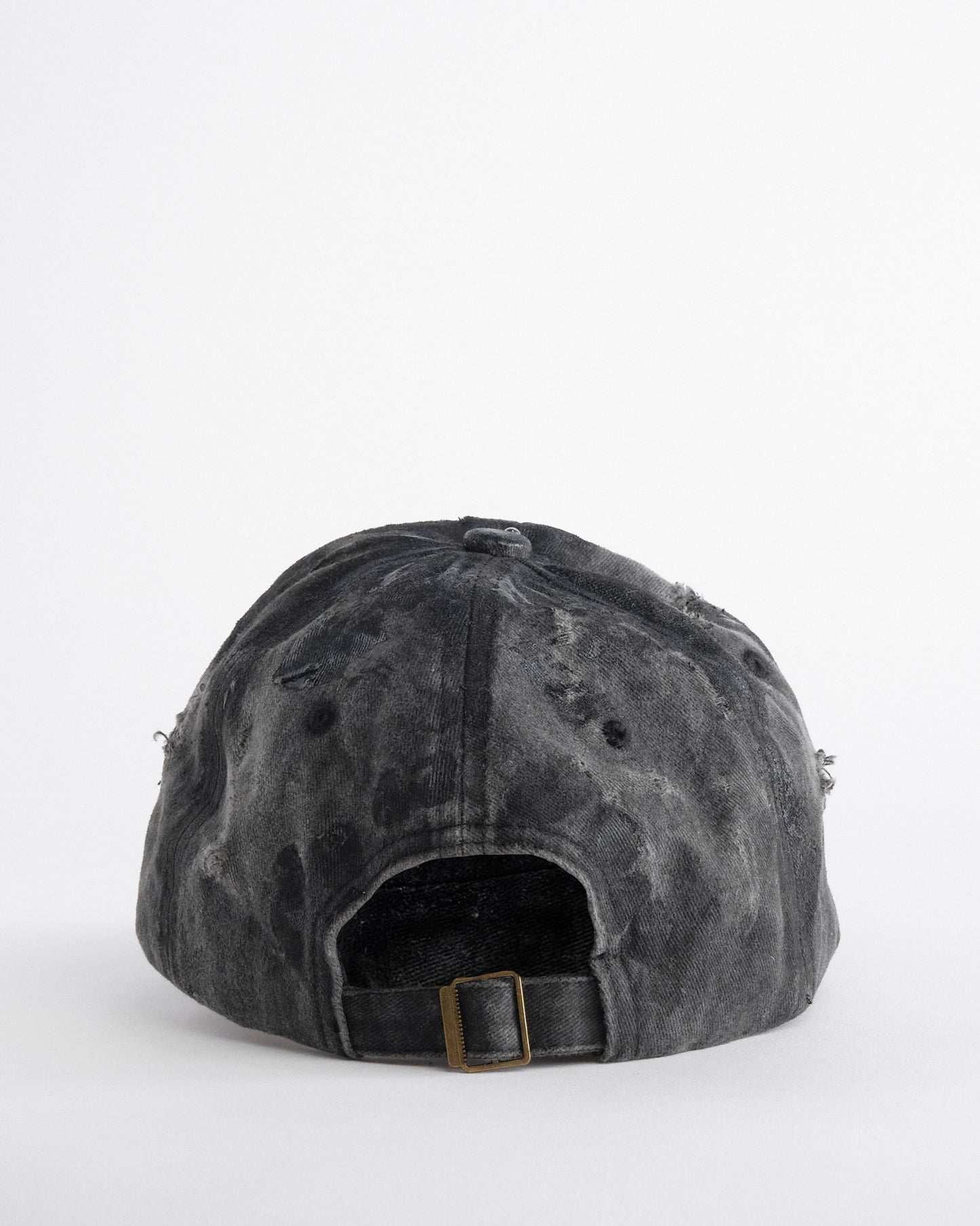 Back of Black distressed half-visor hat with barbed-wire logo, adjustable strap, black paint details, and stainless steel piercings along the brim.