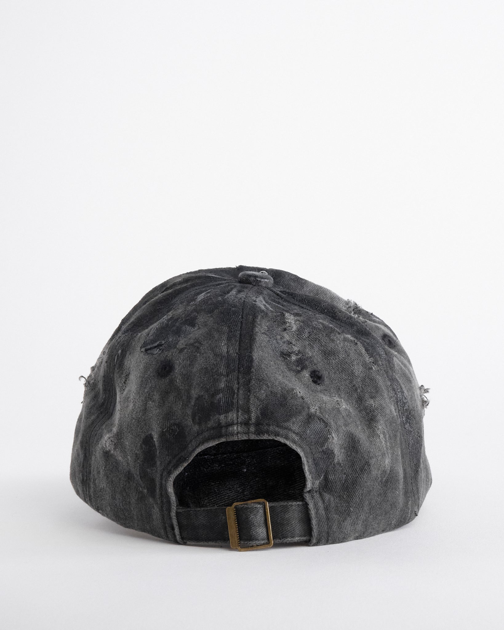 Back of Black distressed half-visor hat with barbed-wire logo, adjustable strap, black paint details, and stainless steel piercings along the brim.