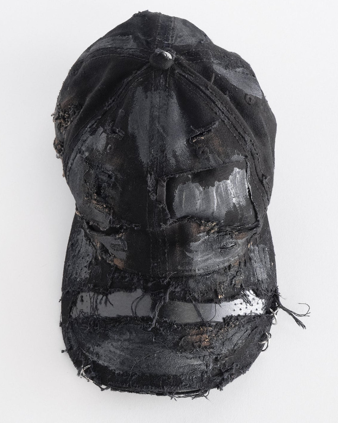 Front top angle of ASTROBOI* black distressed denim hat with faded finish, layered black paint, and sterling silver piercings, customized in NYC.