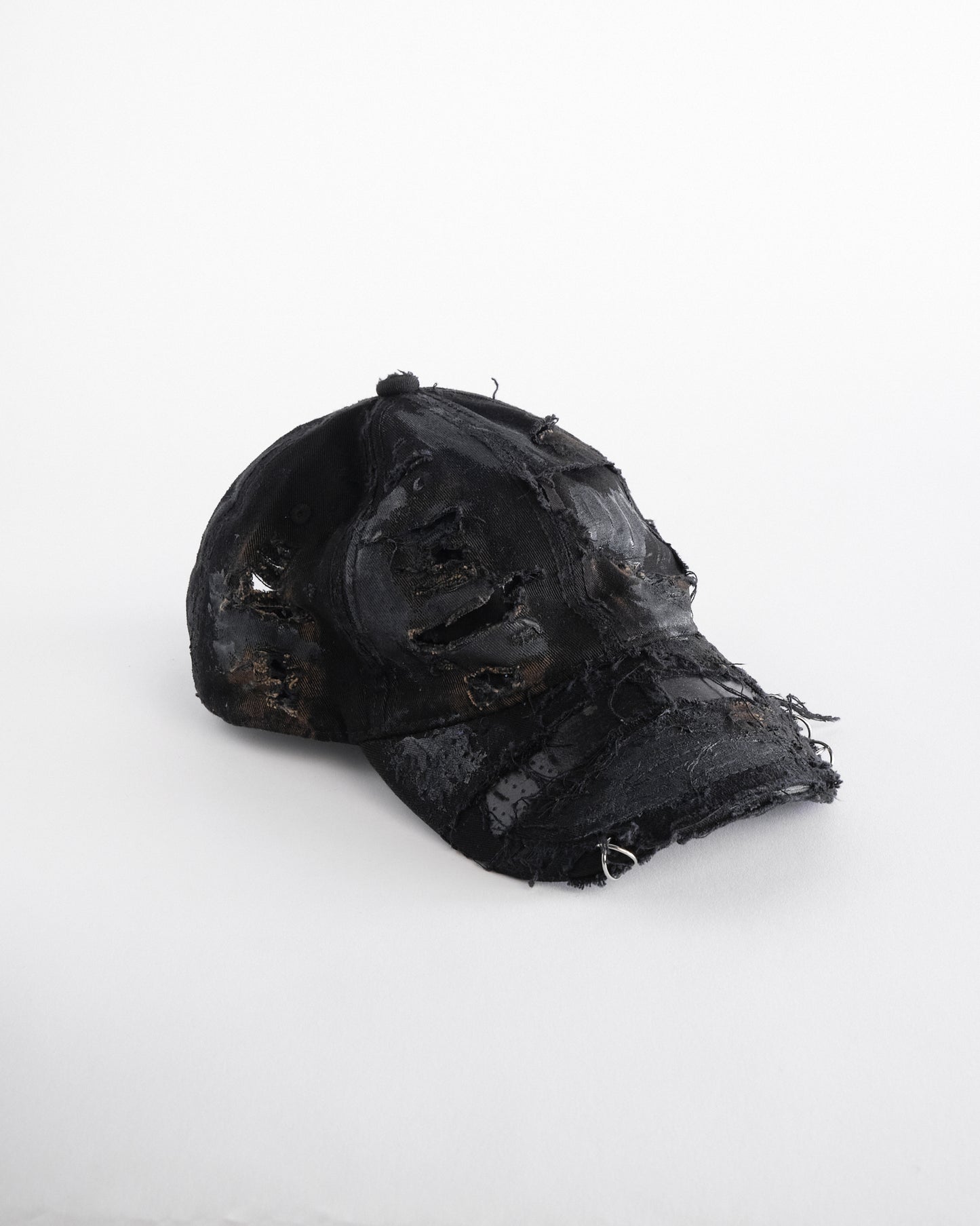 Front right side of ASTROBOI* black distressed denim hat with faded finish, layered black paint, and sterling silver piercings, customized in NYC.