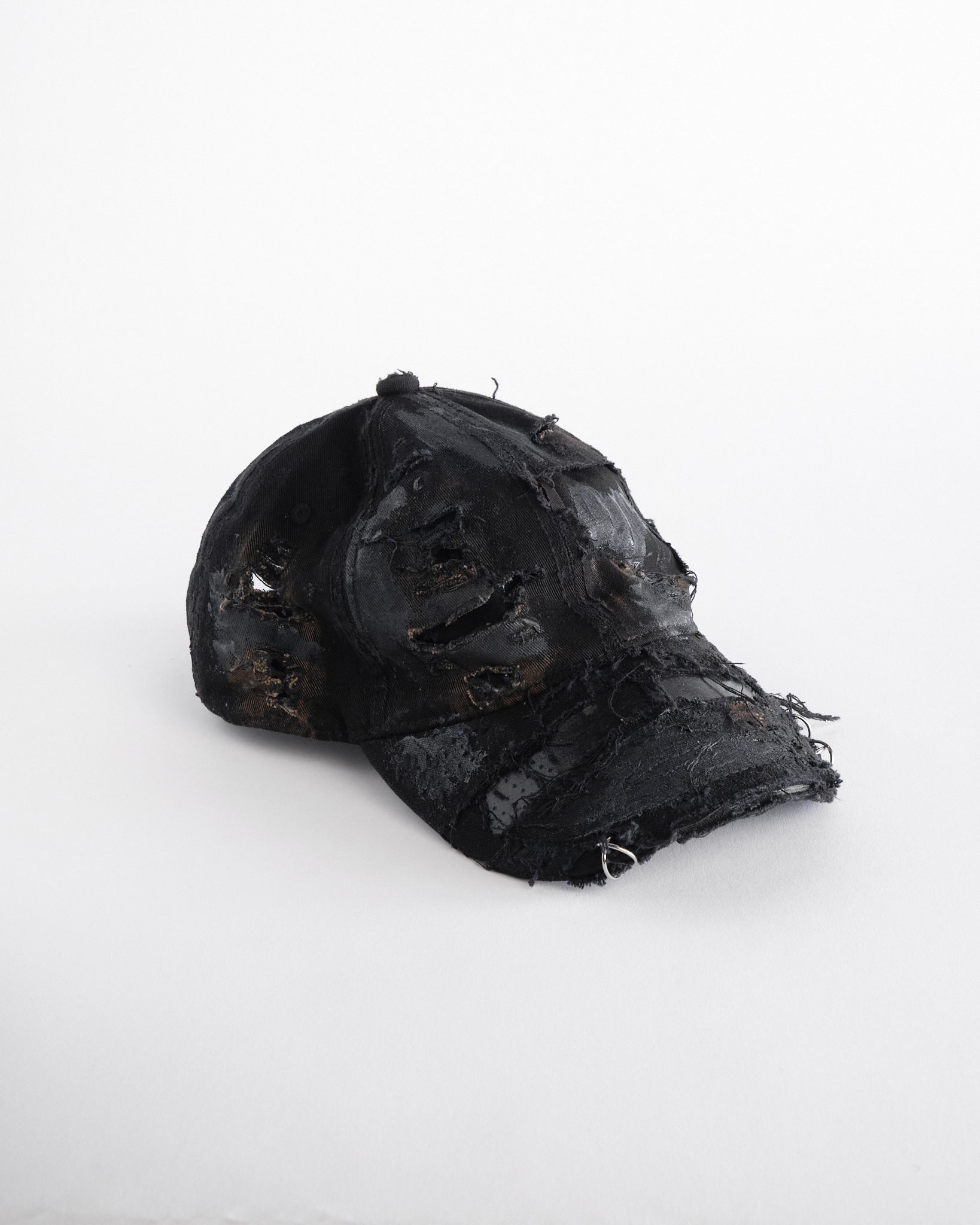 Front right side of ASTROBOI* black distressed denim hat with faded finish, layered black paint, and sterling silver piercings, customized in NYC.