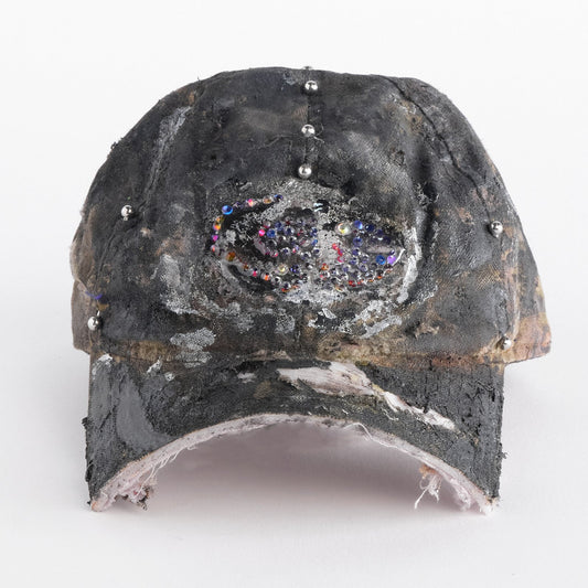 Front side of ASTROBOI* x Mossy Oak brown real tree camo half visor hat with rhinestone resin logo and stainless steel piercings.