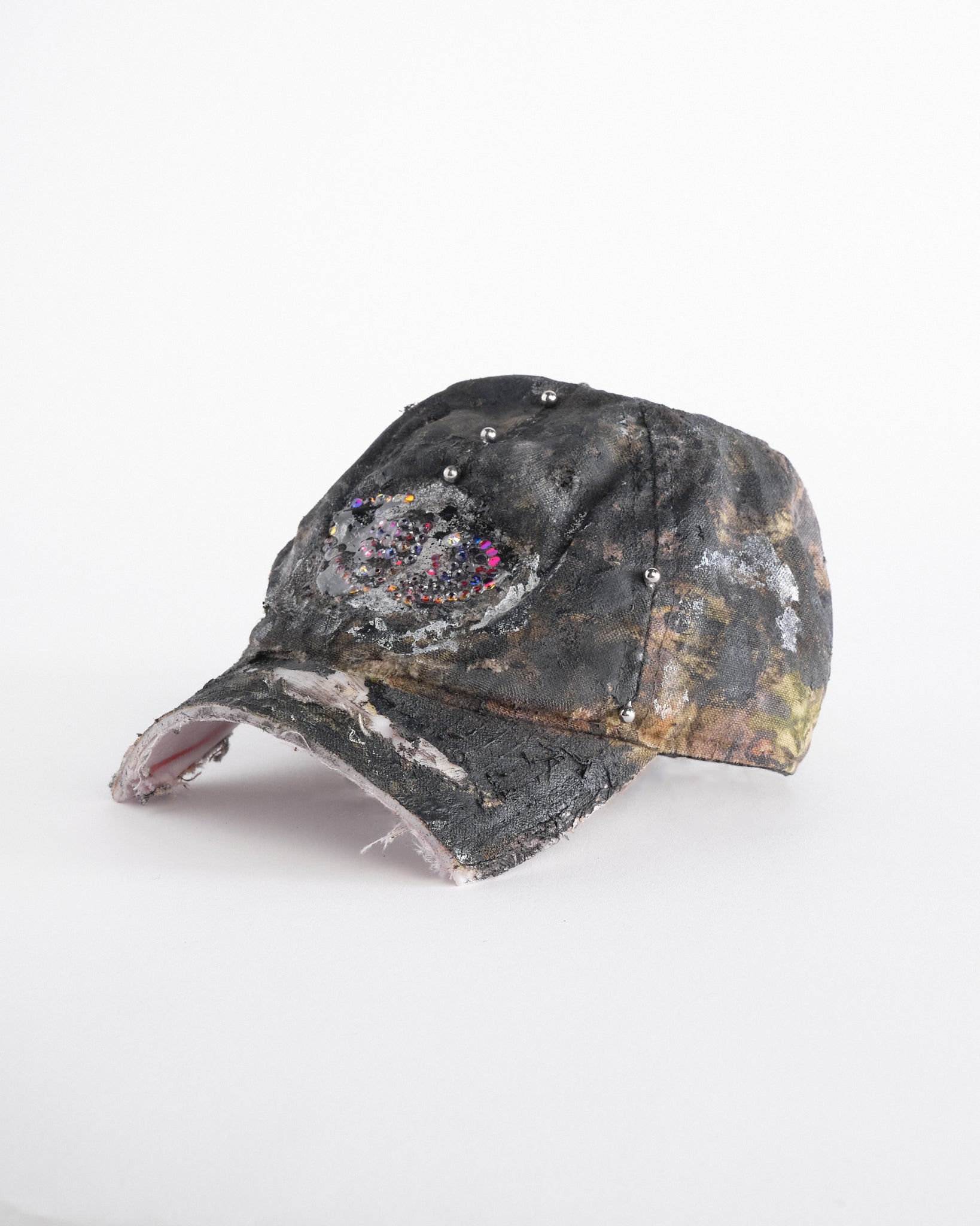 Left side of ASTROBOI* x Mossy Oak brown real tree camo half visor hat with rhinestone resin logo and stainless steel piercings.