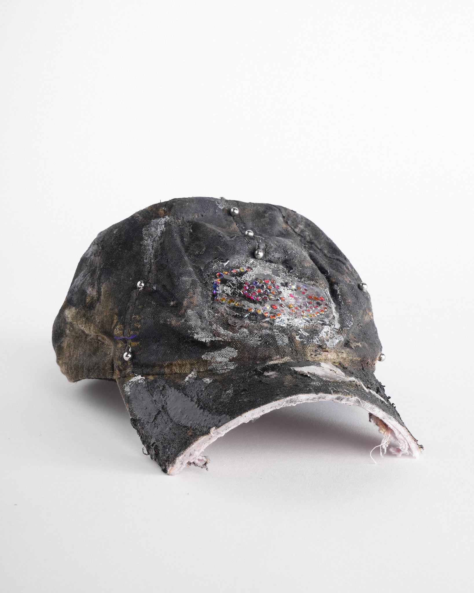 Front right side of side of ASTROBOI* x Mossy Oak brown real tree camo half visor hat with rhinestone resin logo and stainless steel piercings.