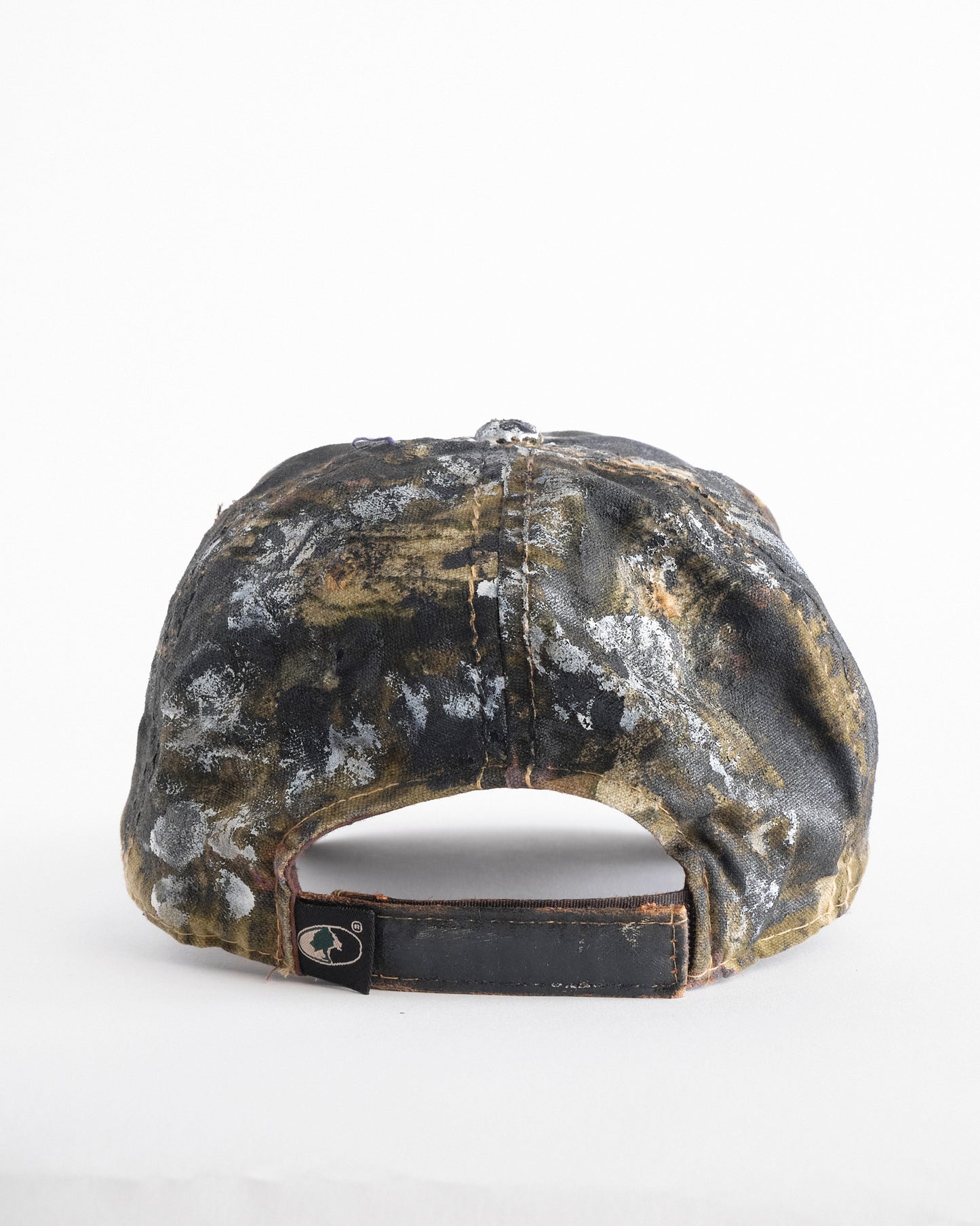 Back of of ASTROBOI* x Mossy Oak brown RealTree camo hat with rhinestones, distressed paint details, and leather visor, adjustable fit.