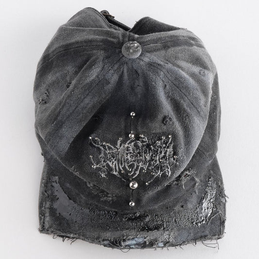 Front top side of ASTROBOI* Chalk black distressed half-visor hat with white airbrush detailing, rhinestones, resin accents, and stainless steel piercings.