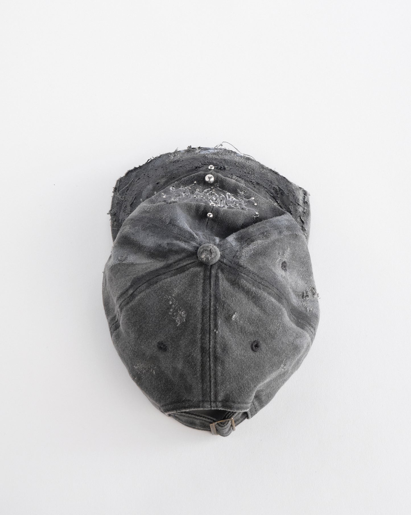 Back top perspective of ASTROBOI* Chalk black distressed half-visor hat with white airbrush detailing, rhinestones, resin accents, and stainless steel piercings.