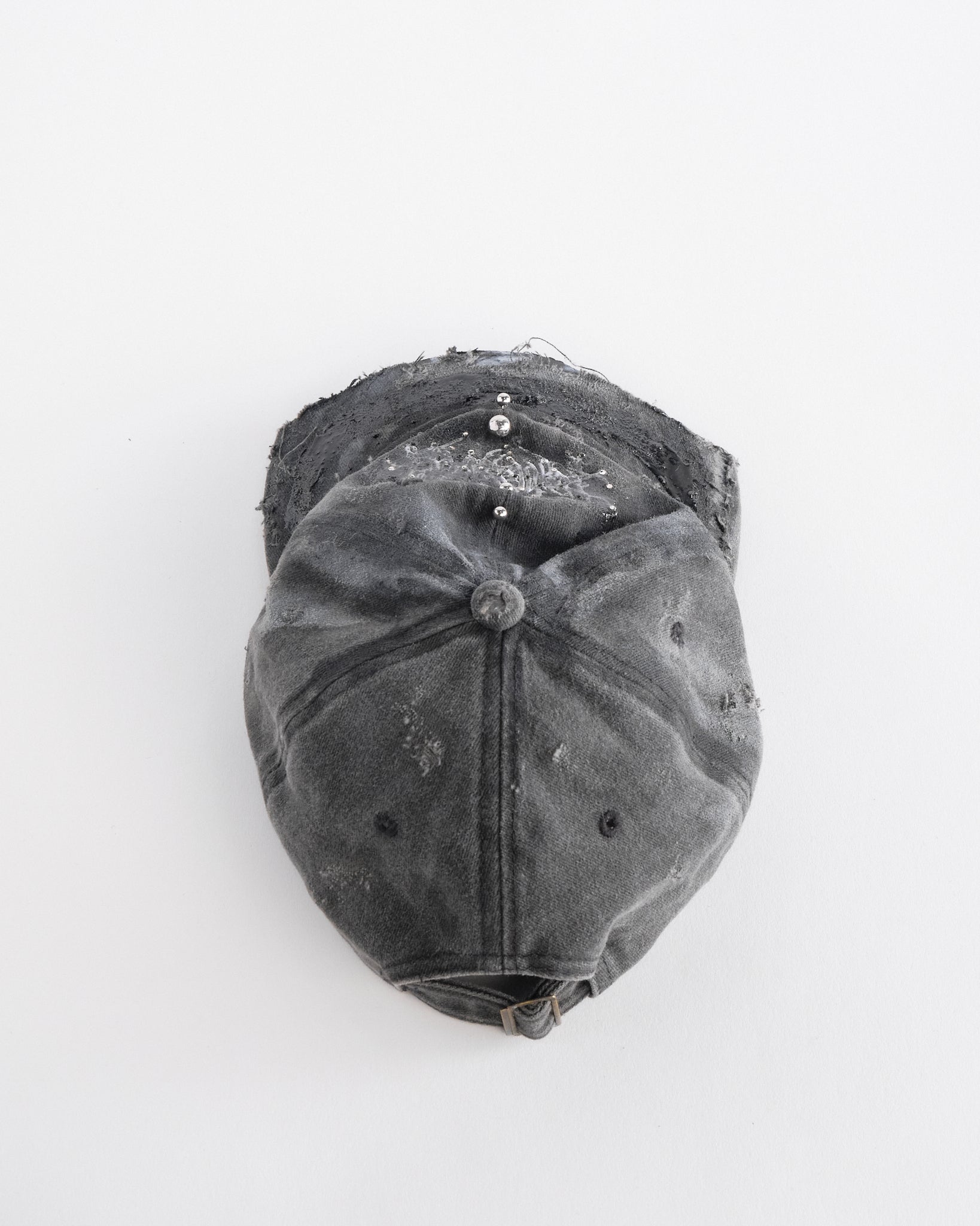 Back top perspective of ASTROBOI* Chalk black distressed half-visor hat with white airbrush detailing, rhinestones, resin accents, and stainless steel piercings.