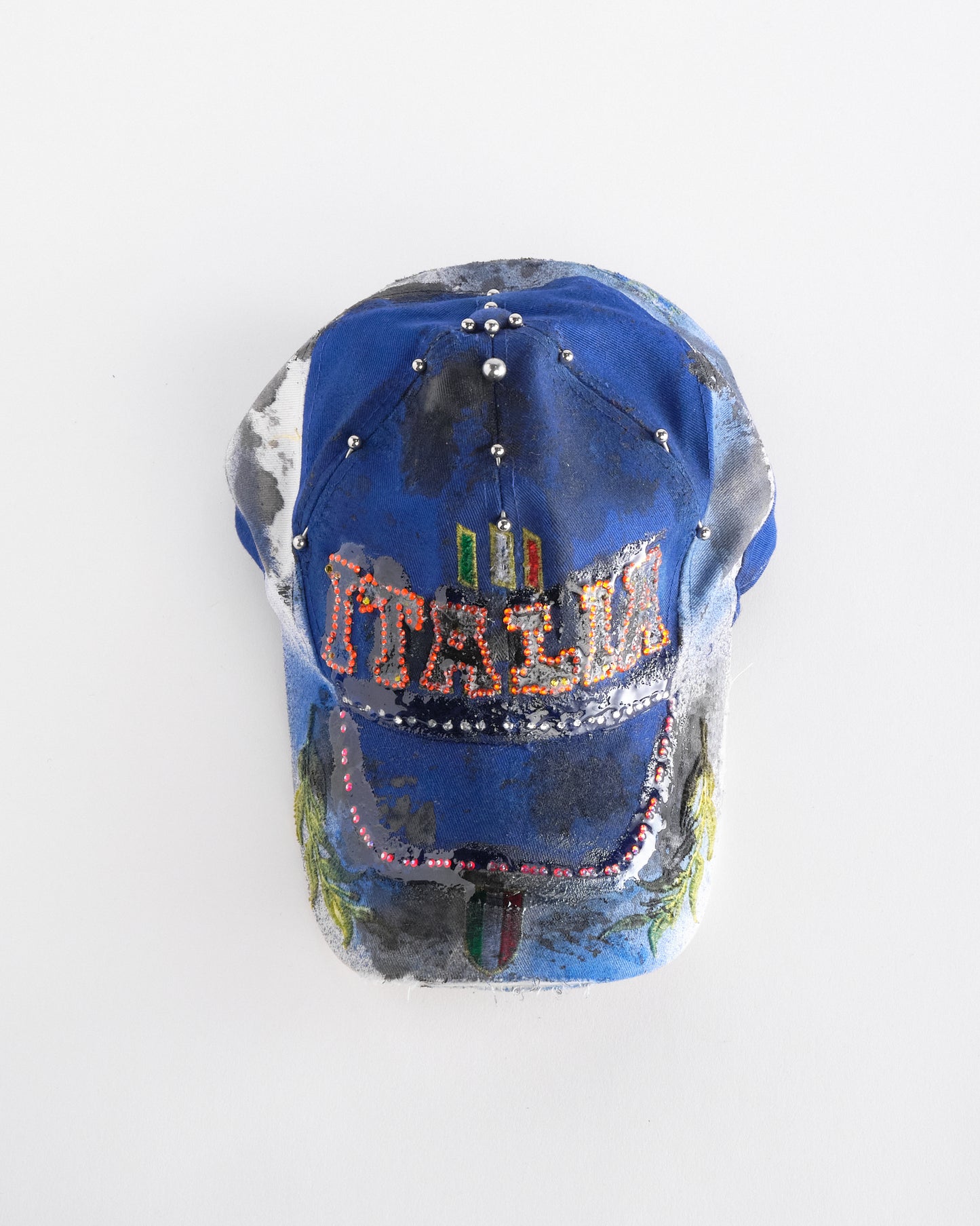 Top front perspective of Upcycled blue and white ASTROBOI* ‘ITALIA’ hat with rhinestones, resin, custom paint, and stainless steel piercings, handcrafted in NYC.