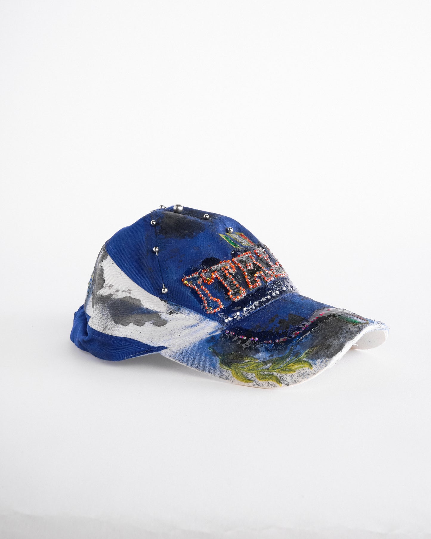 Right of Upcycled blue and white ASTROBOI* ‘ITALIA’ hat with rhinestones, resin, custom paint, and stainless steel piercings, handcrafted in NYC.