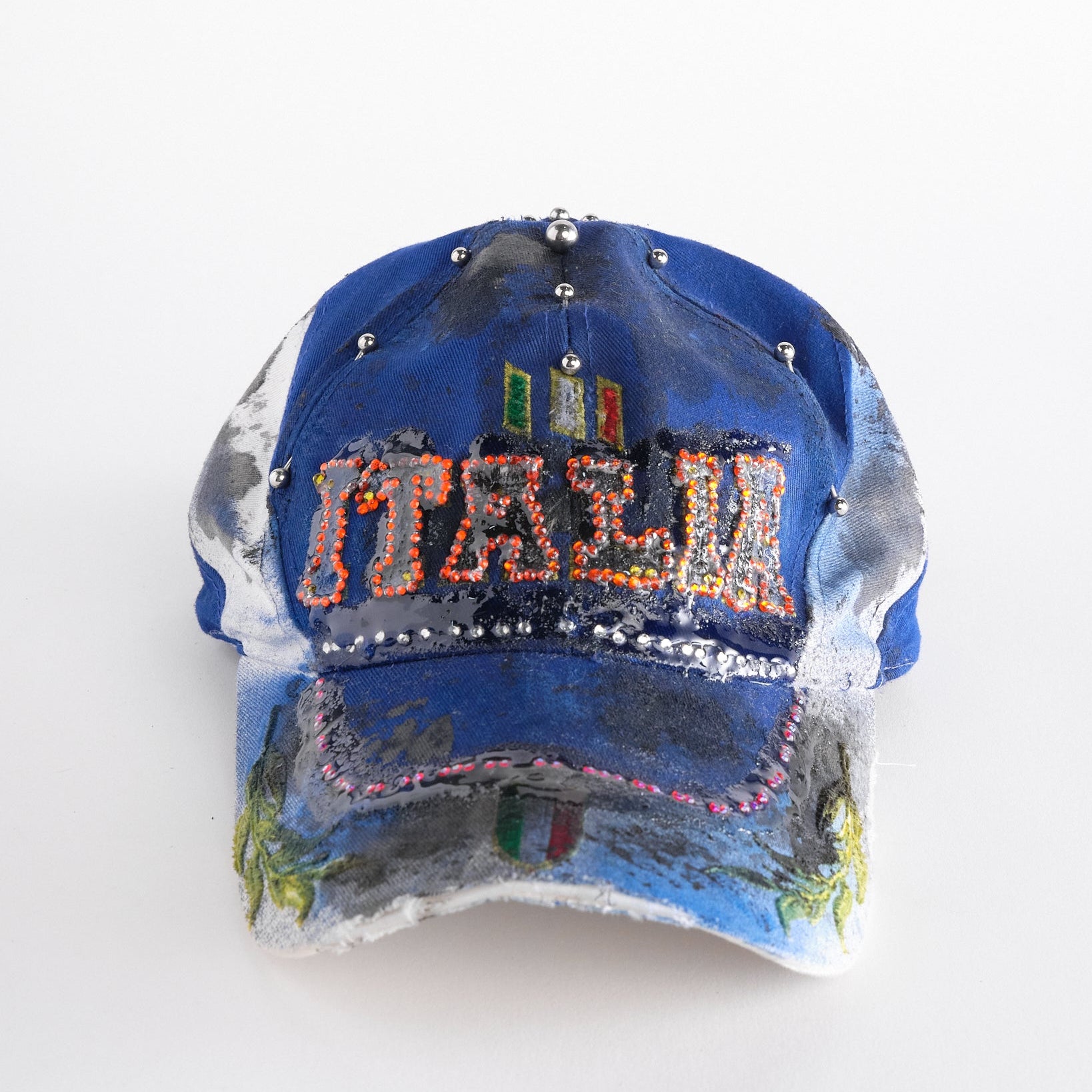 Front of Upcycled blue and white ASTROBOI* ‘ITALIA’ hat with rhinestones, resin, custom paint, and stainless steel piercings, handcrafted in NYC.