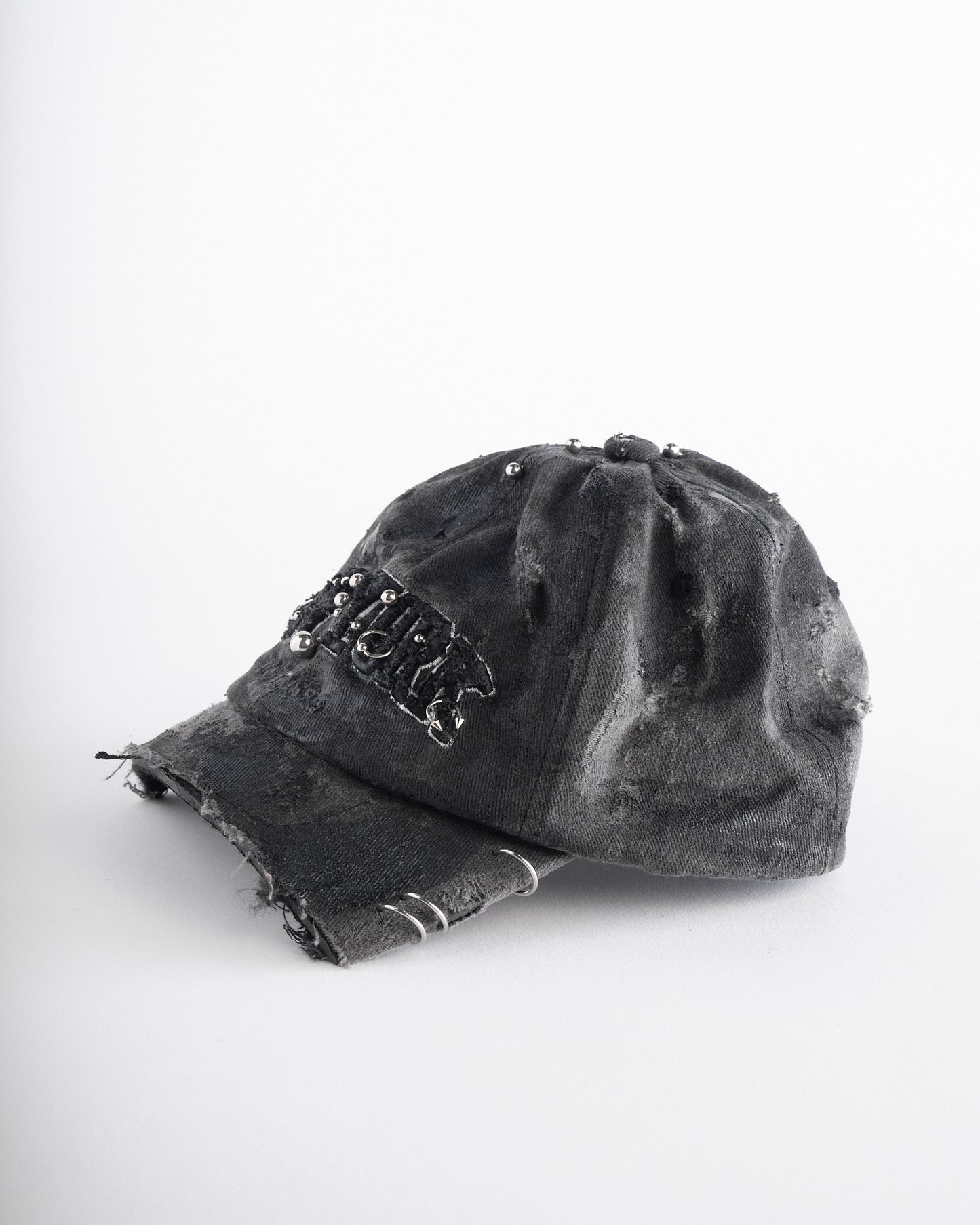 Left of of Black half-visor “New York” hat with embroidered front logo, stainless steel piercings, and an adjustable strap.