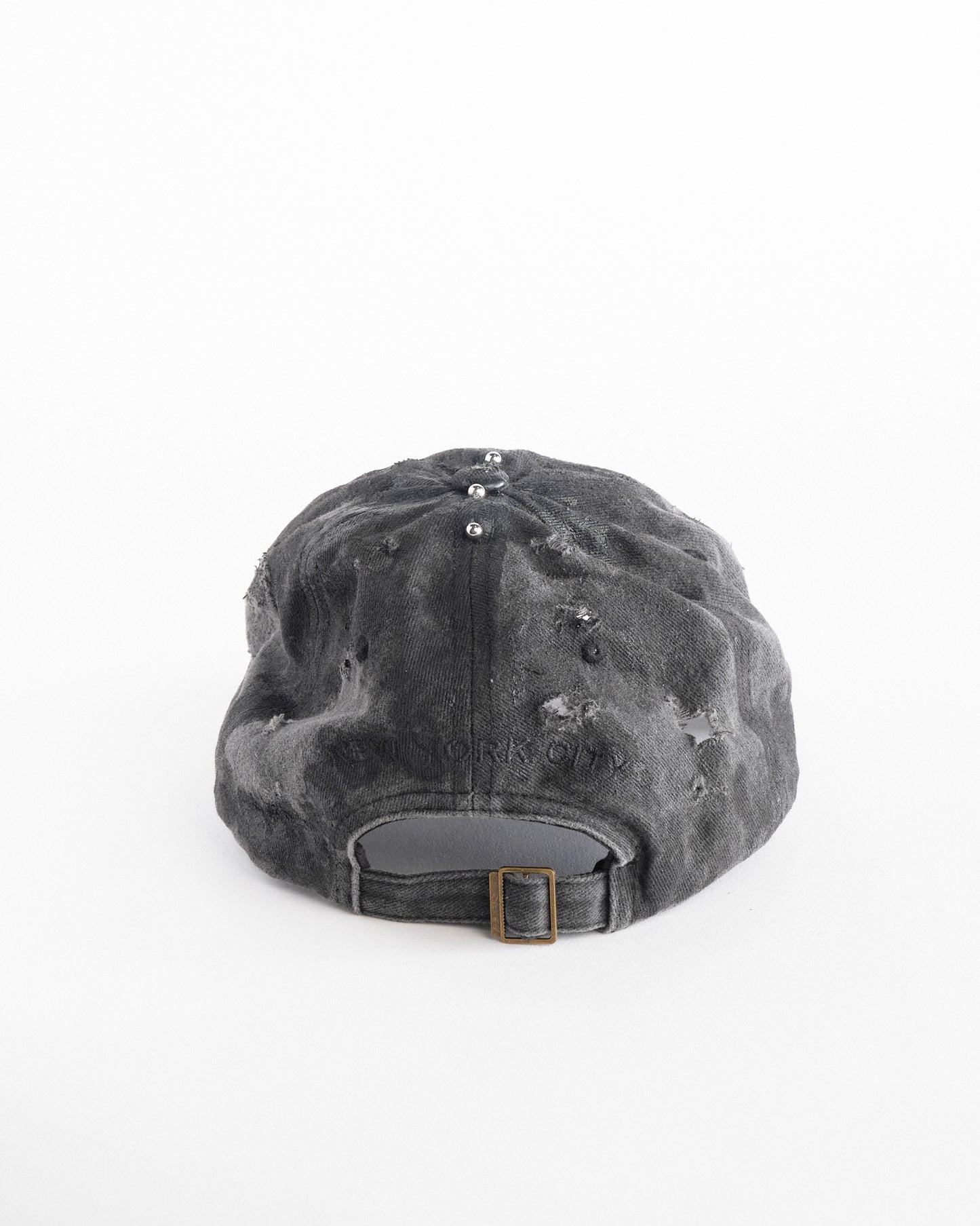 Back of Black half-visor “New York” hat with embroidered front logo, stainless steel piercings, and an adjustable strap.