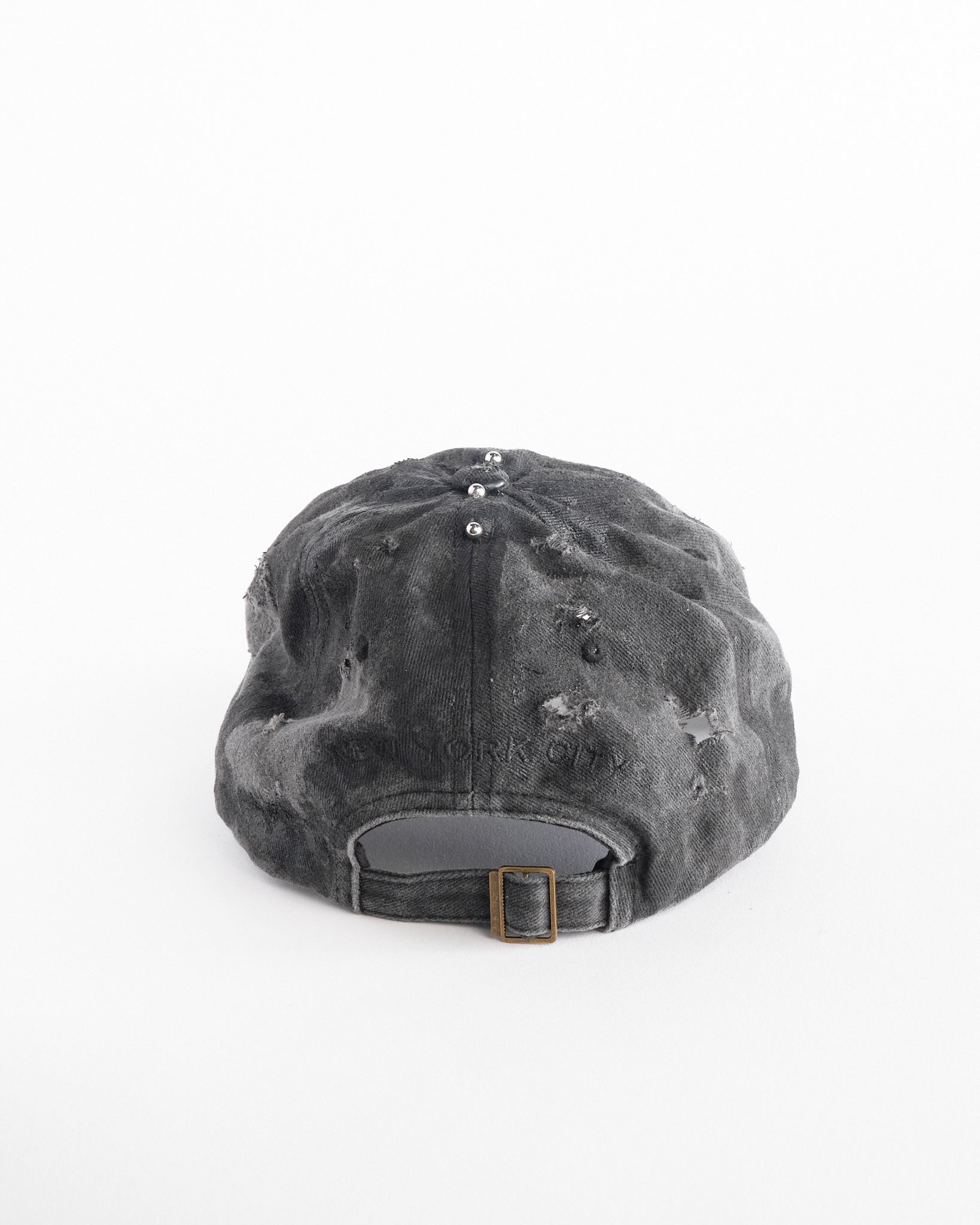 Back of Black half-visor “New York” hat with embroidered front logo, stainless steel piercings, and an adjustable strap.