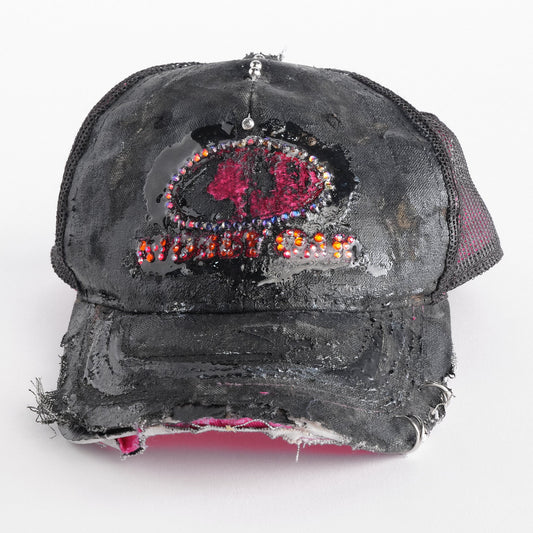 Front of ASTROBOI* x Mossy Oak black and pink distressed rhinestone hat with resin logo and mesh back panel