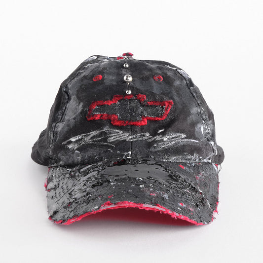 Front of of Black and red Chevy Racing hat customized by ASTROBOI* with distressing, painted details, glossy resin visor, and stainless steel piercings.