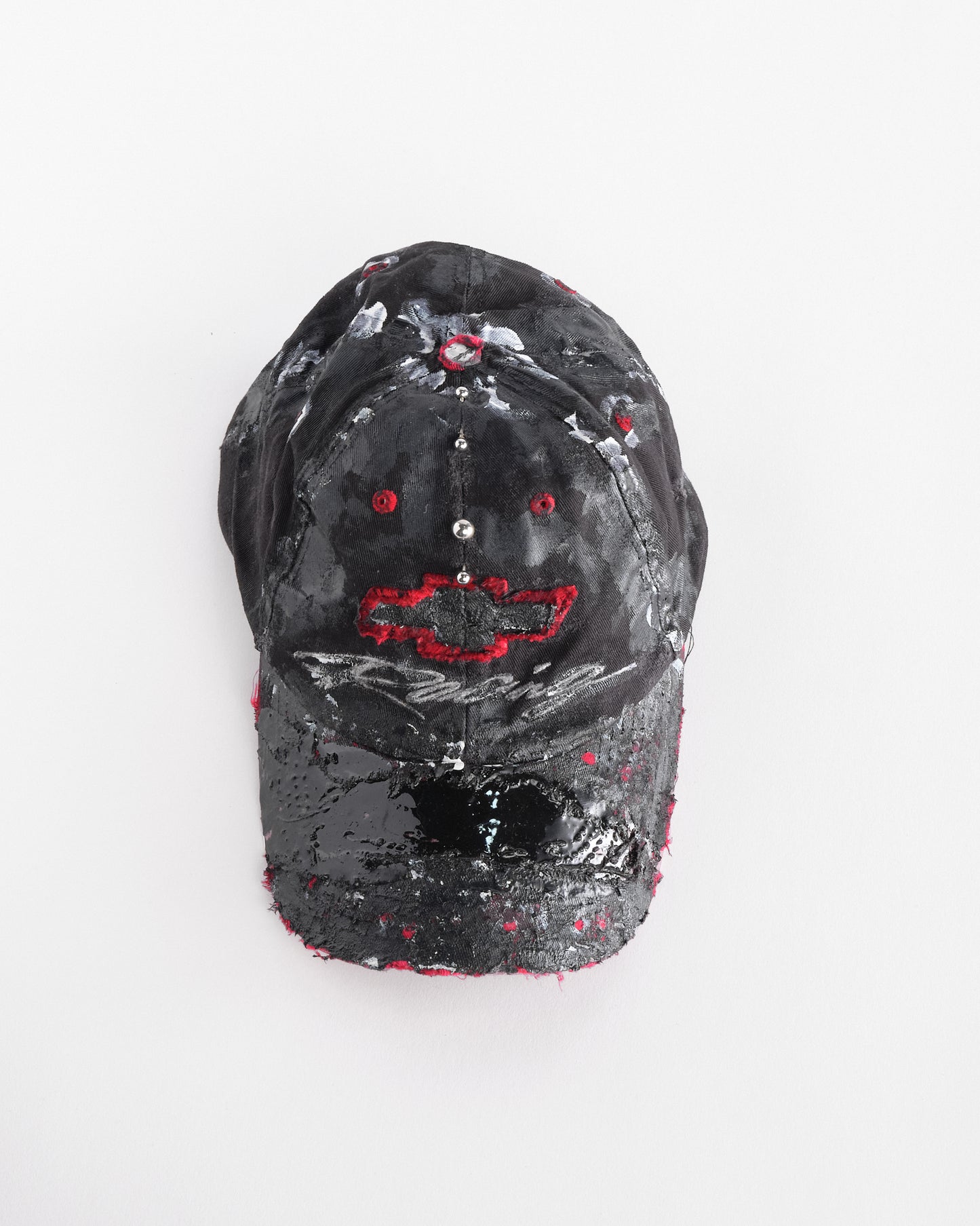 Top front of Black and red Chevy Racing hat customized by ASTROBOI* with distressing, painted details, glossy resin visor, and stainless steel piercings.